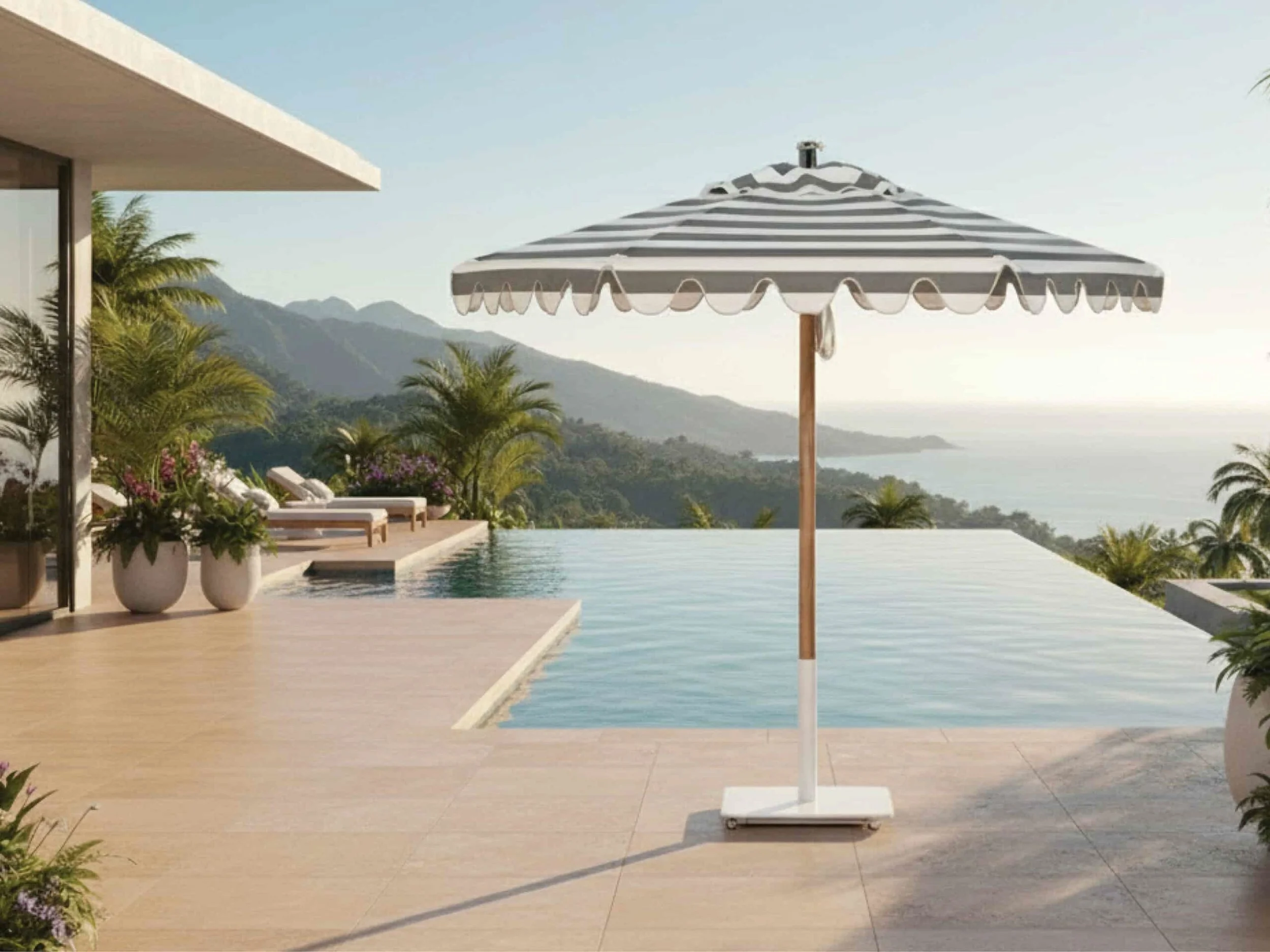 Poolside scene with a striped patio umbrella, potted plants, and mountain views in the background.