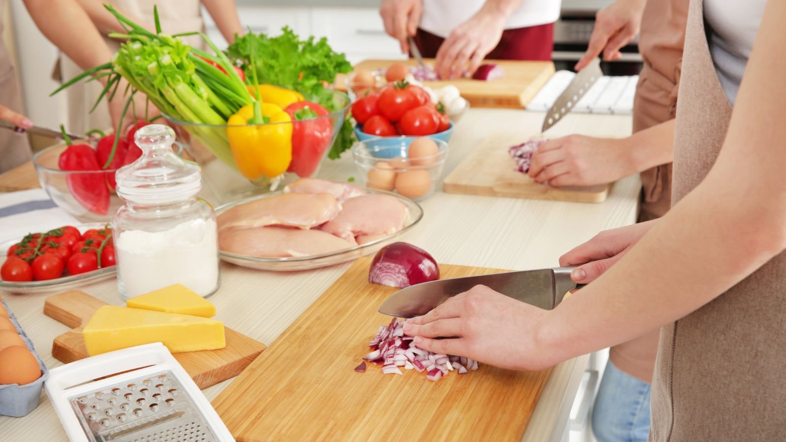Travelers at a cooking class, representing memorable vacation experiences worth planning for.