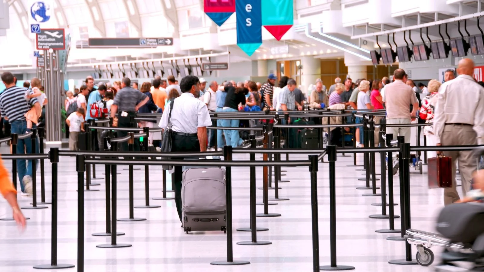 Travelers waiting in line at airport customs after an international flight.