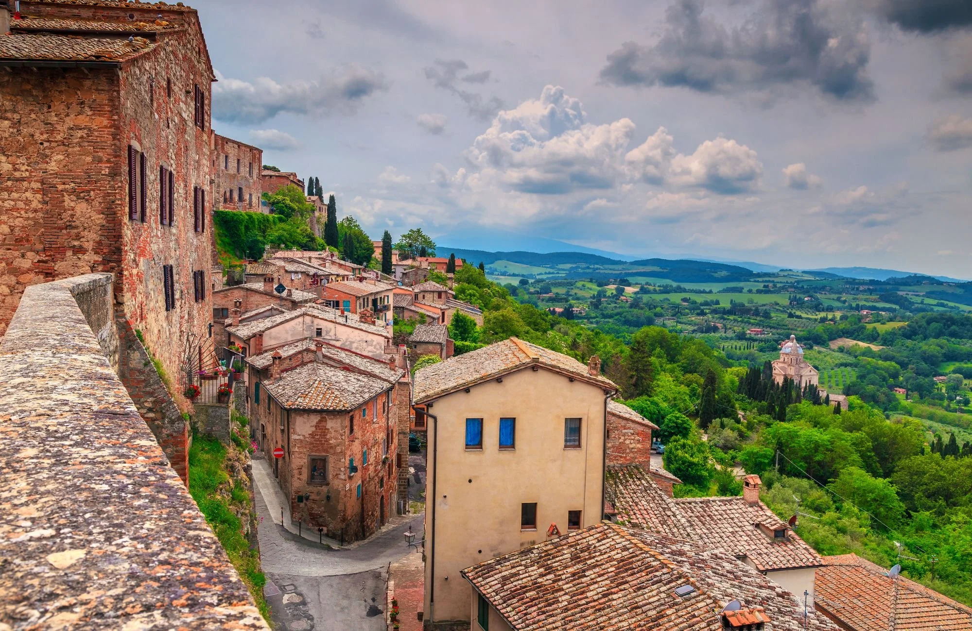 A European town perched on a hill overlooking a green countryside.
