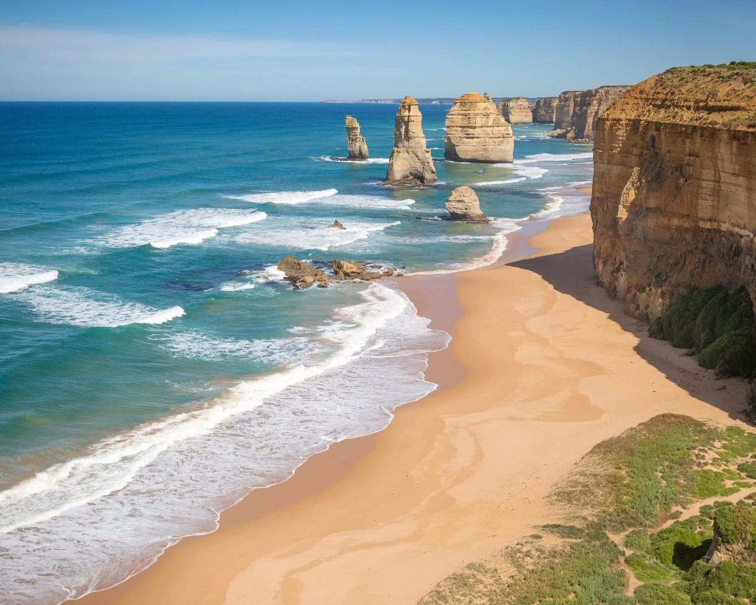 A beach on the Australian coast with a dramatic coastline and golden sand.