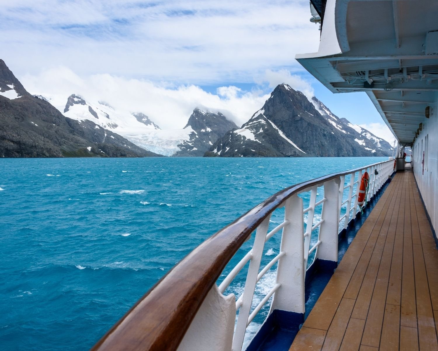 Views of snow-capped mountains in the distance and water from an Alaskan cruise ship.