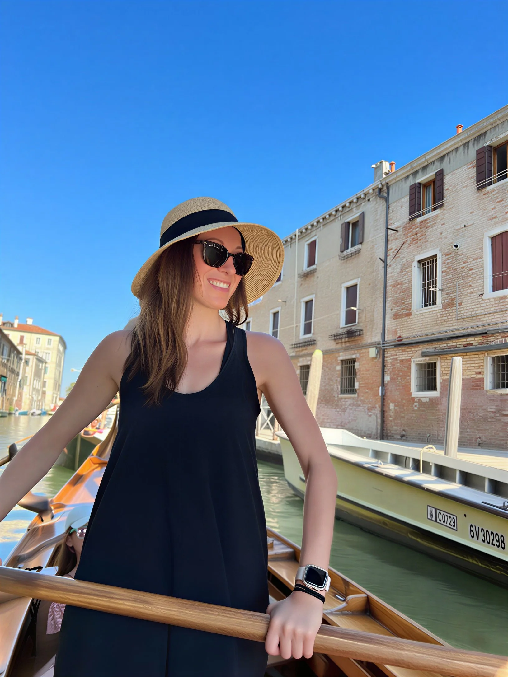 Jaimie, the owner of Branch and Bloom Travel, rowing a gondola in a canal in Venice, Italy.