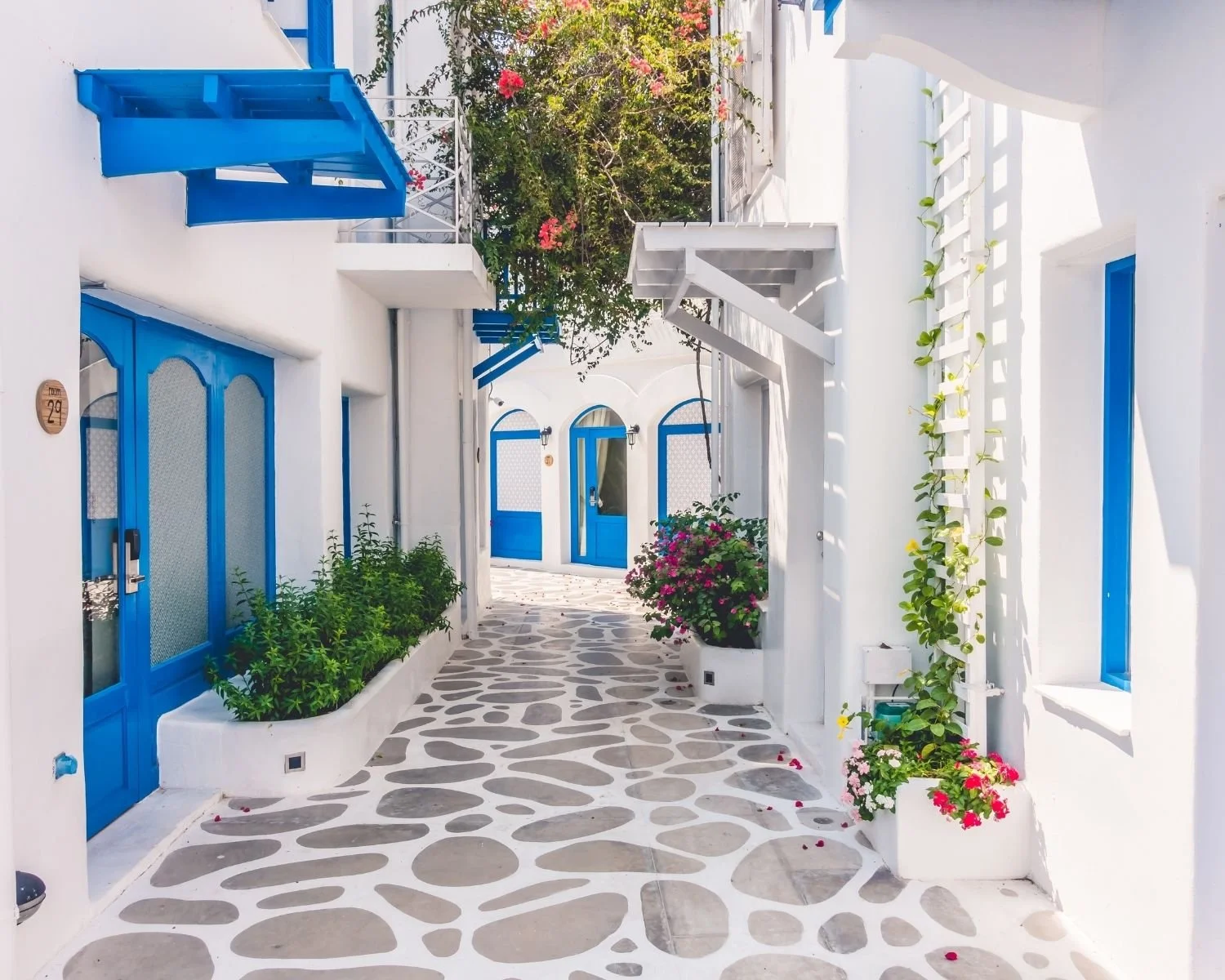 White Mediterranean street with blue doors in Greece