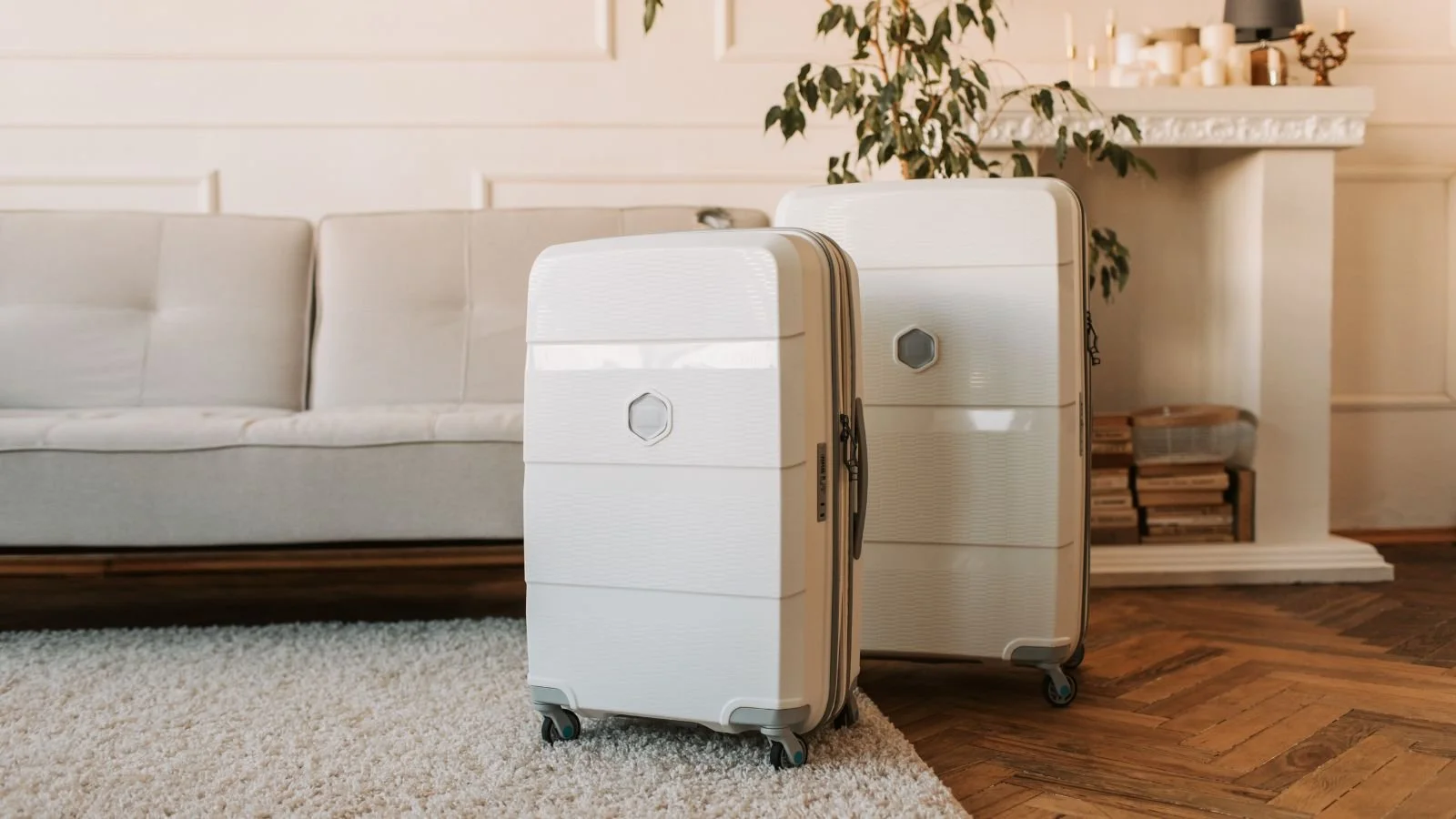 Two white suitcases packed and ready for departure in a living room.