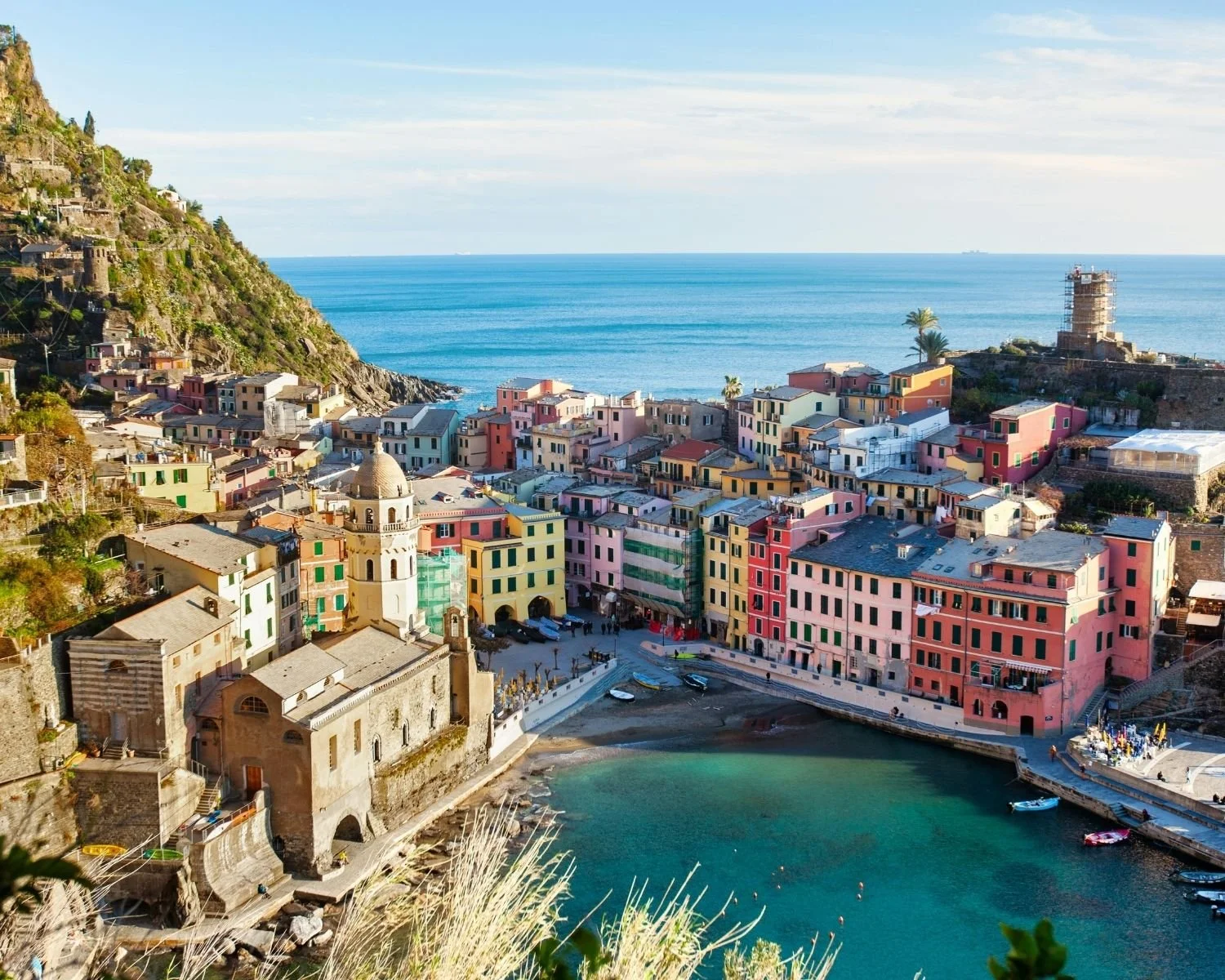 A colorful village in Cinque Terre, Italy with boats and a sea view.