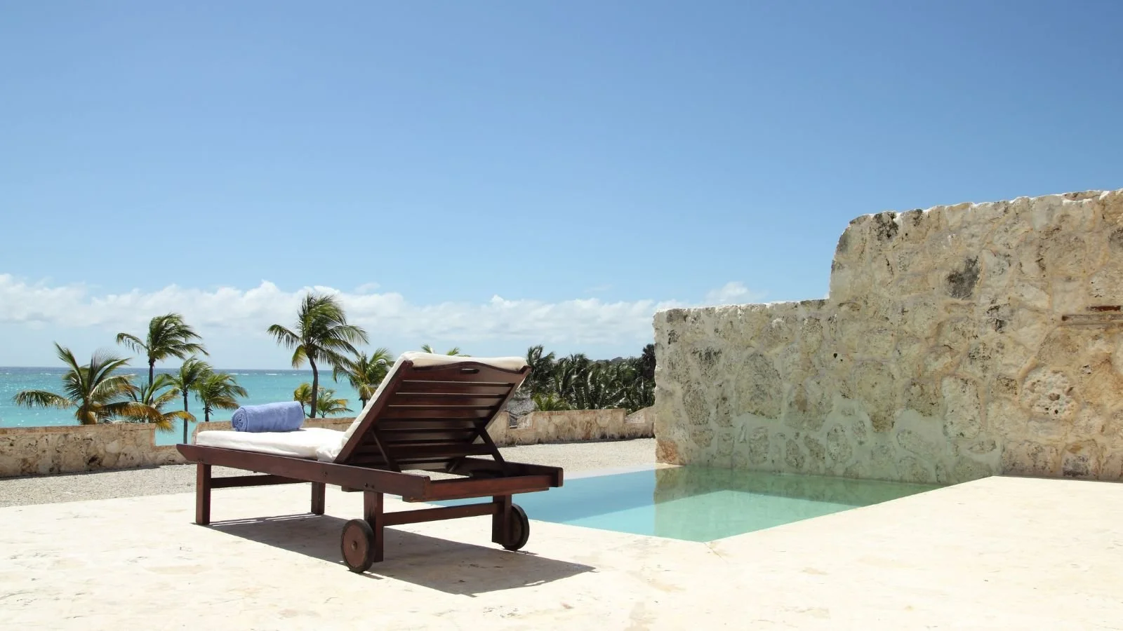 Private pool at an accommodation overlooking a tropical beach and ocean.