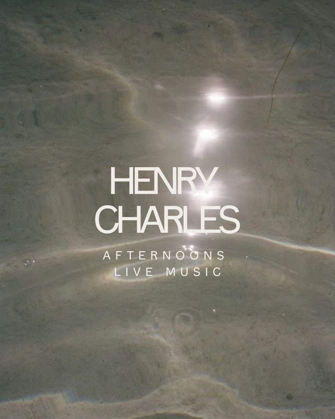 A promotional poster for Henry Charles' afternoon live music event, featuring a reflective, abstract background with floating light reflections.