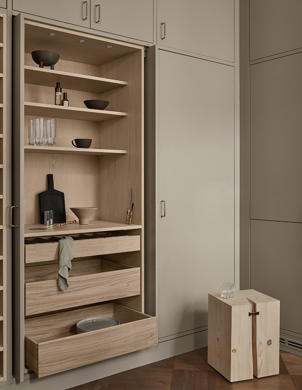 Detail of a Stockholm apartment kitchen. Coffee cabinet with pocket doors in a warm beige. 