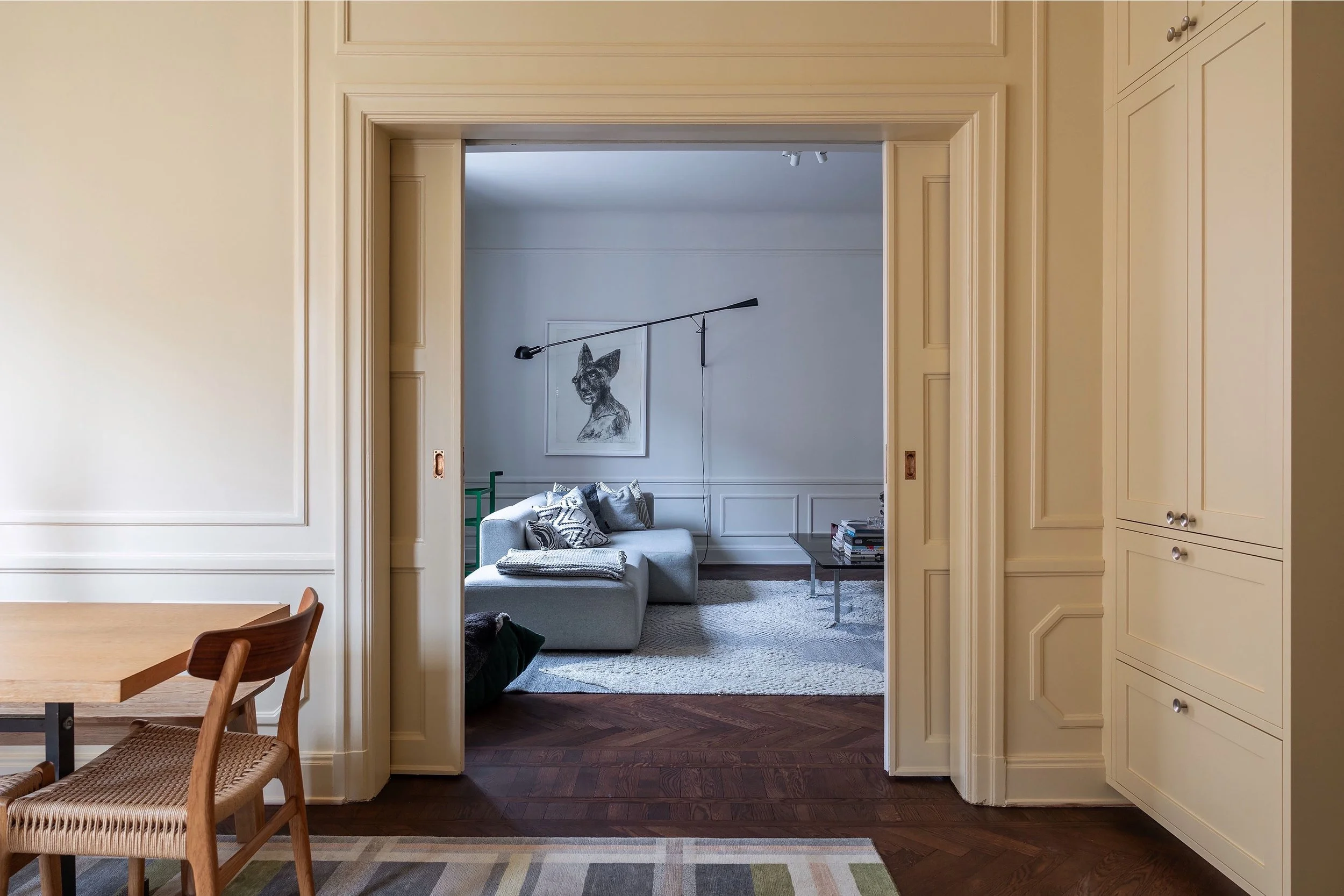 Living room viewed from the butter yellow kitchen in an apartment renovation. 
