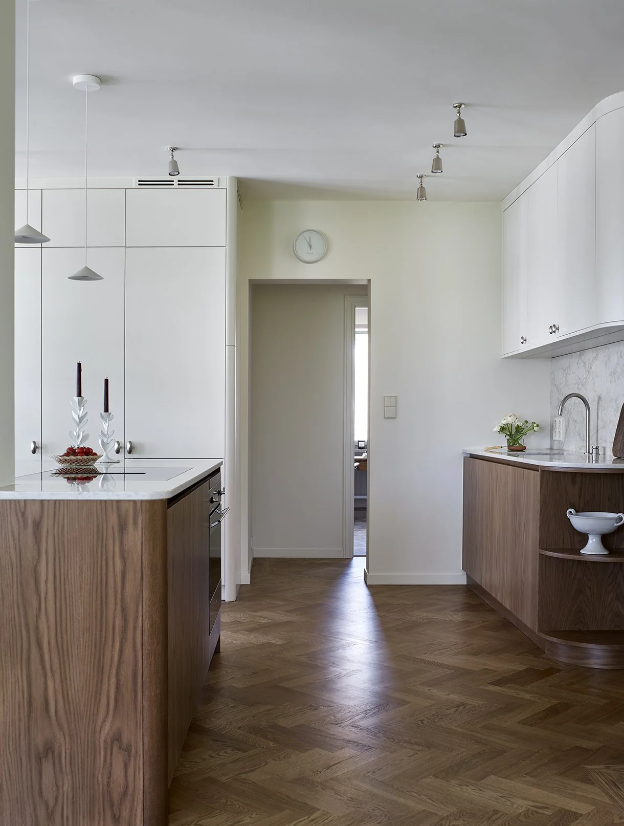 View of a modern kitchen with wooden cabinets and vanilla toned accents, topped off with a marble countertop, 