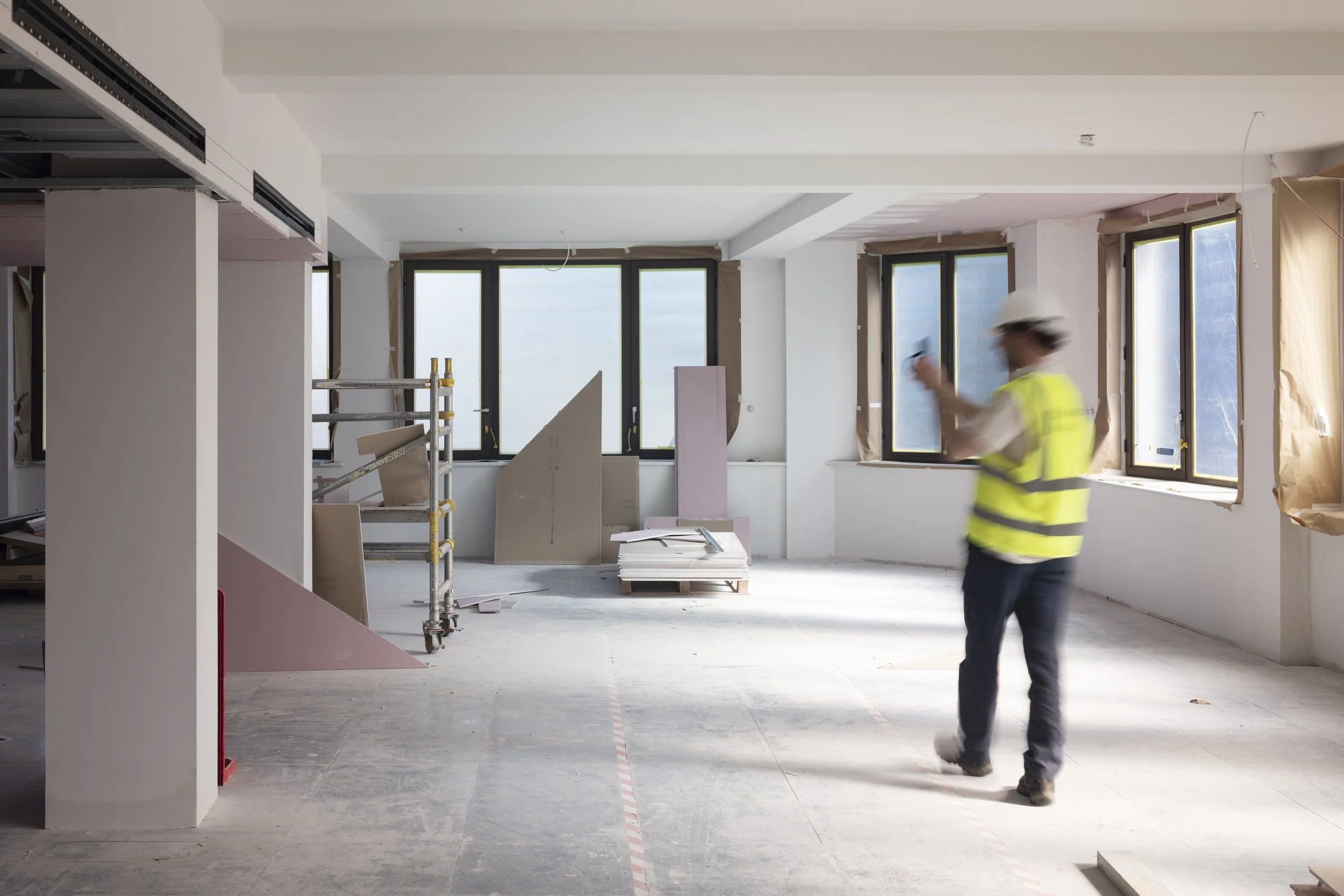Worker inspecting a stripped-out building interior during a pre-refurbishment audit survey