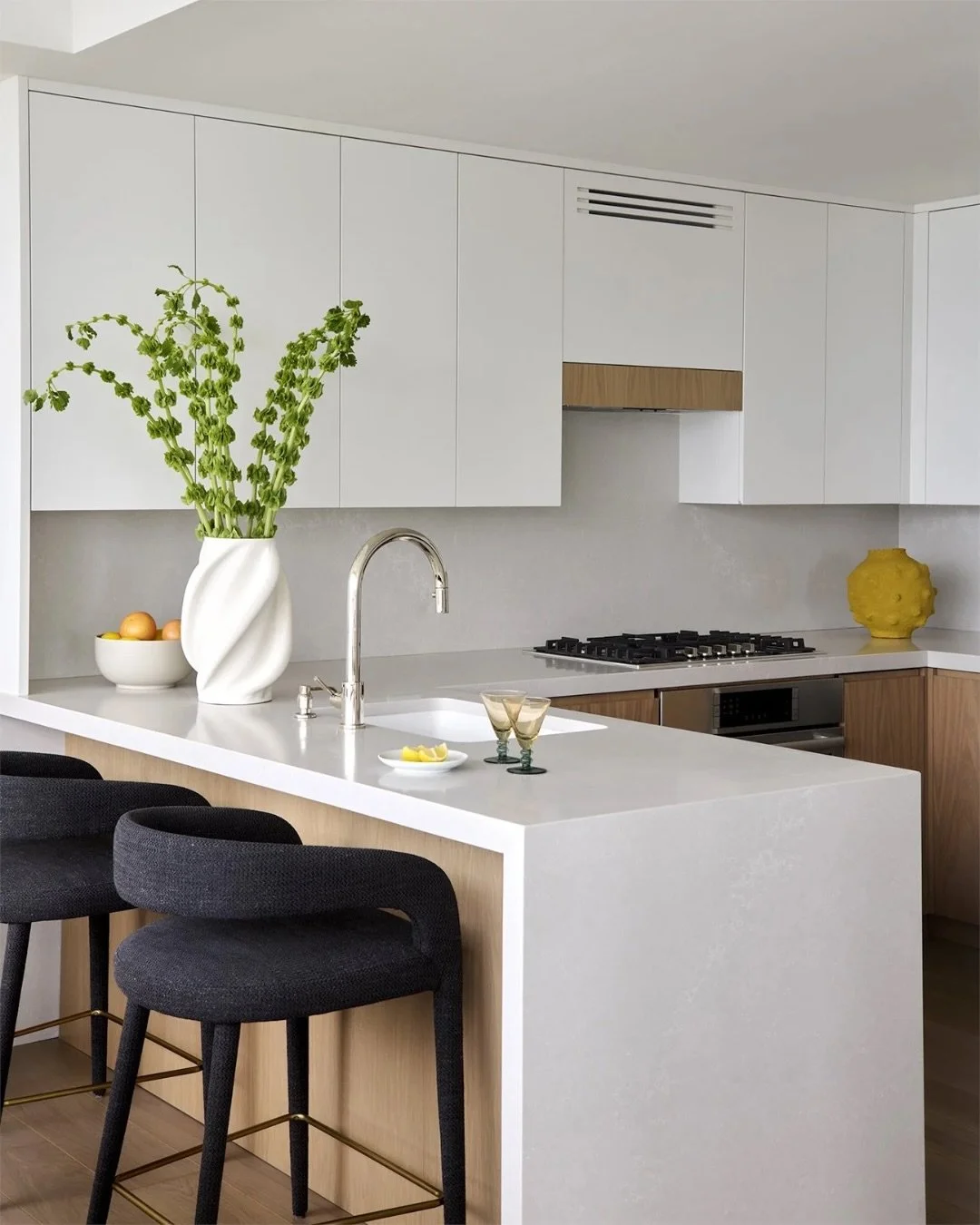 We warmed up this white kitchen with natural wood tones. Open to the living area, it&rsquo;s become the true heart of the home. 🤎

Design: @hco_interiors
Photo: @mcbecks_pix