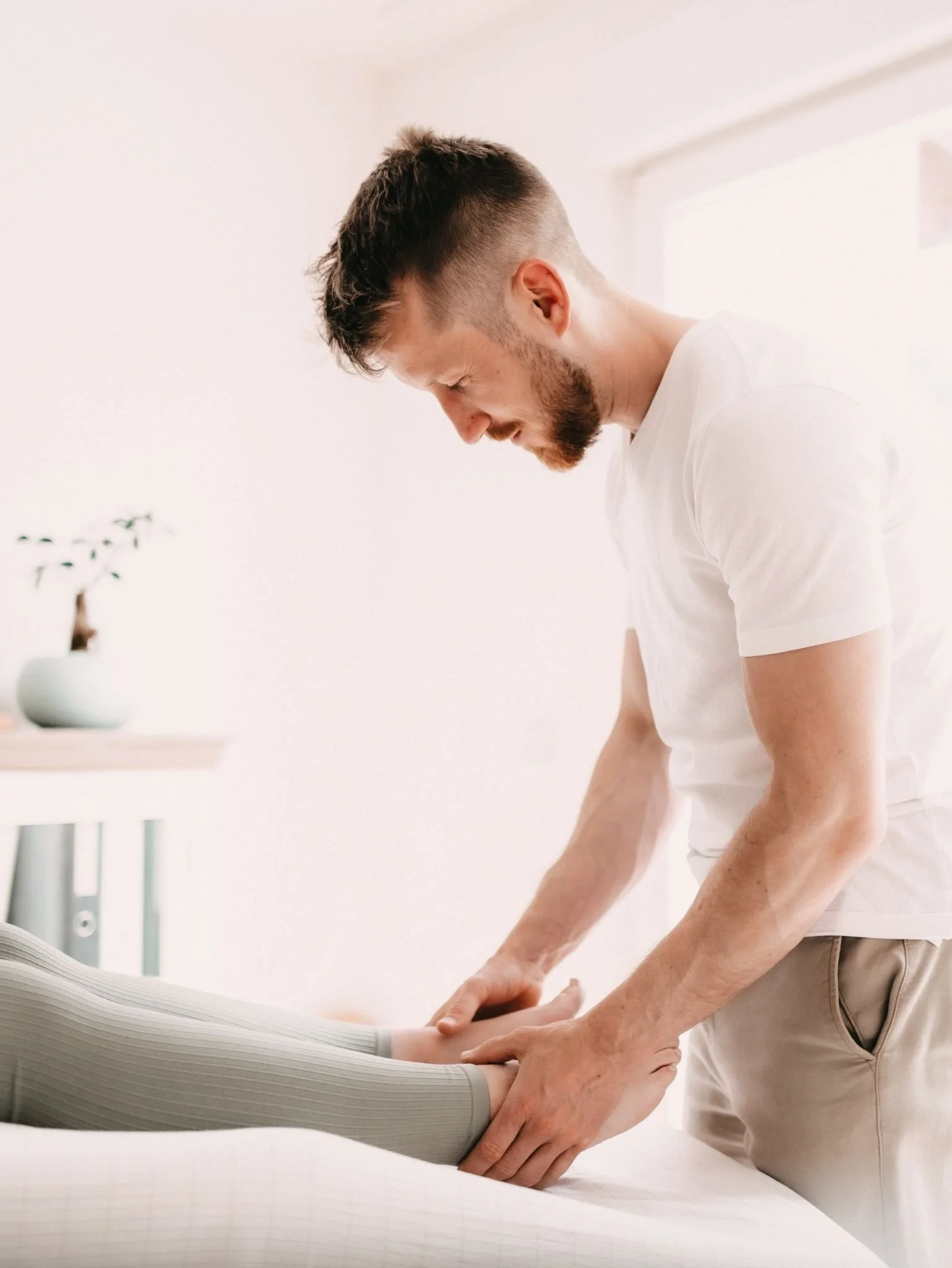 Osteopath Johannes Thies behandelt das Bein einer Patientin in seiner Praxis in Darmstadt.