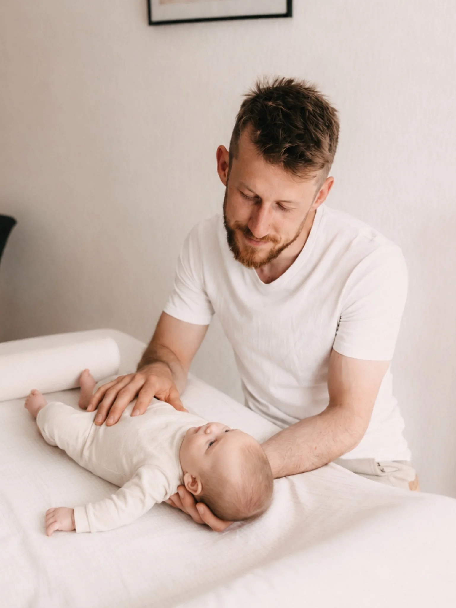 Johannes Thies bei der sanften osteopathischen Behandlung eines Babys in seiner Praxis in Darmstadt.