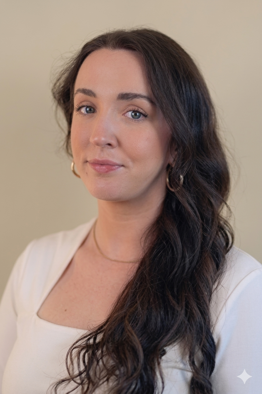 A young woman with long wavy dark brown hair, wearing a white top and gold jewelry, looking at the camera against a plain beige background. Online CEUs in New York State