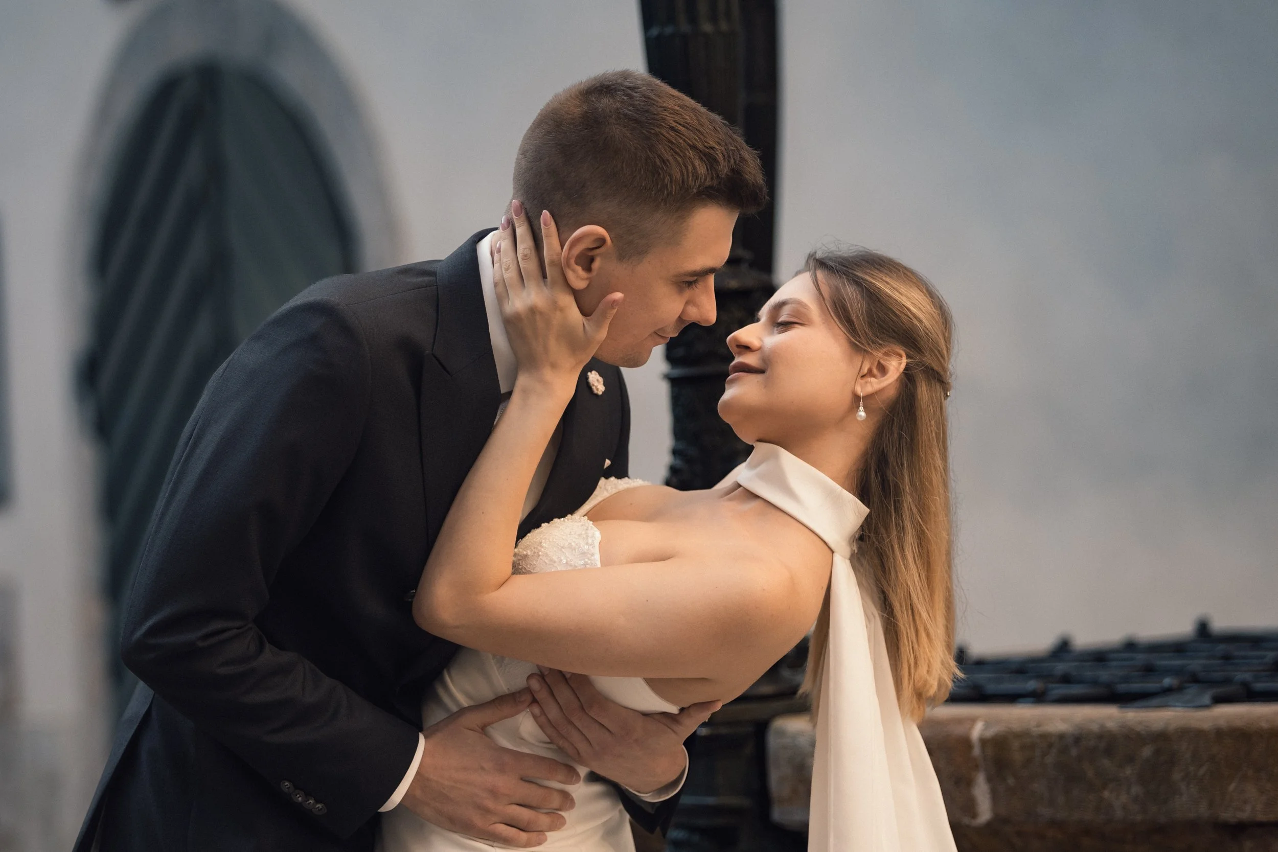 Ein Paar tanzt eng umarmend in einem Raum, vermutlich bei einer Hochzeit oder Feier, beide lächeln liebevoll.