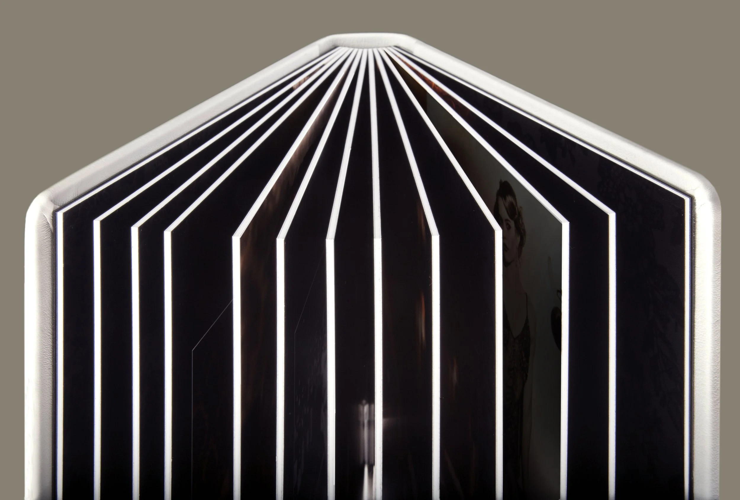 Nahaufnahme eines modernen, schwarzen und weißen Leuchtendesigns mit vertikalen Linien und reflektierender Oberfläche.