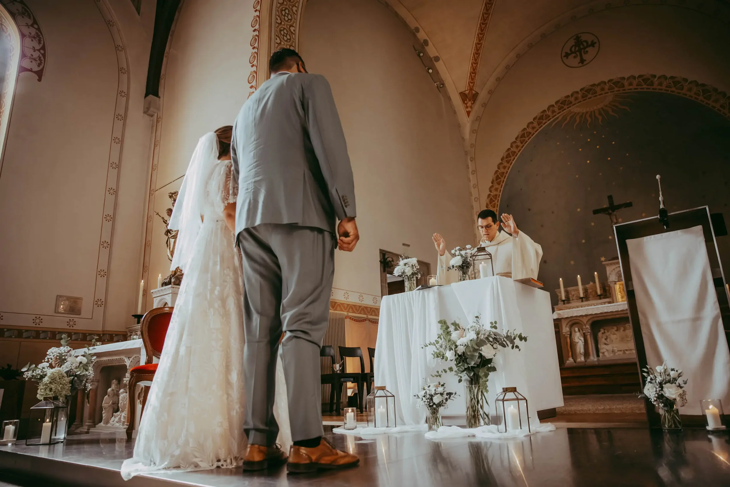 Hochzeitszeremonie in einer Kirche mit Braut, Bräutigam, Priester und dekorativen Blumen und Kerzen auf dem Altar.
