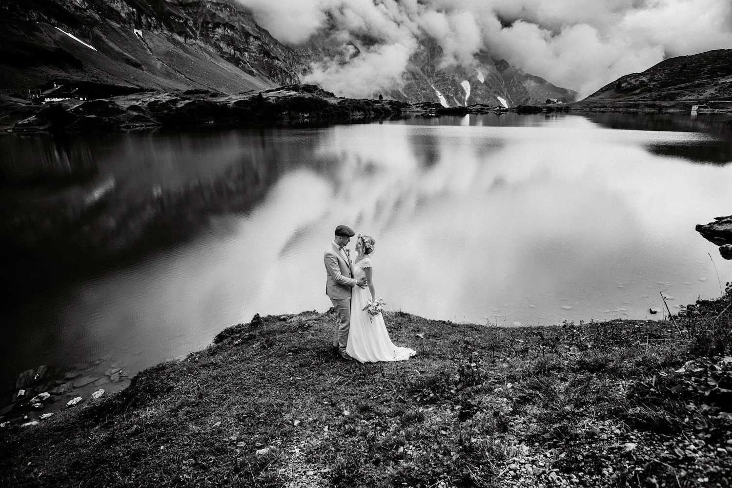 Brautpaar am See in einer Berglandschaft – Schwarz-Weiß-Fotografie von Hedrich Weddings