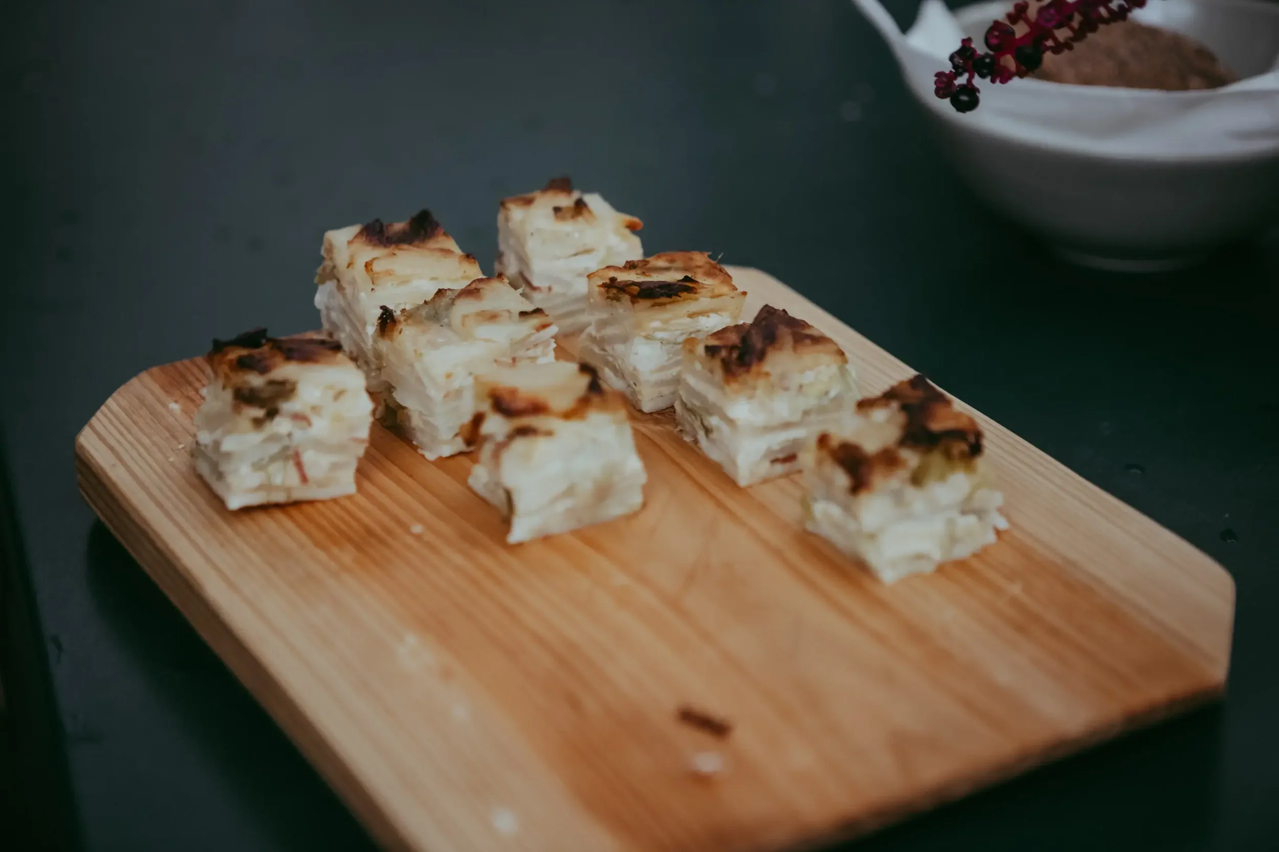 Kleine Schichtkuchen mit geschmolzener Oberseite auf Holzbrett.