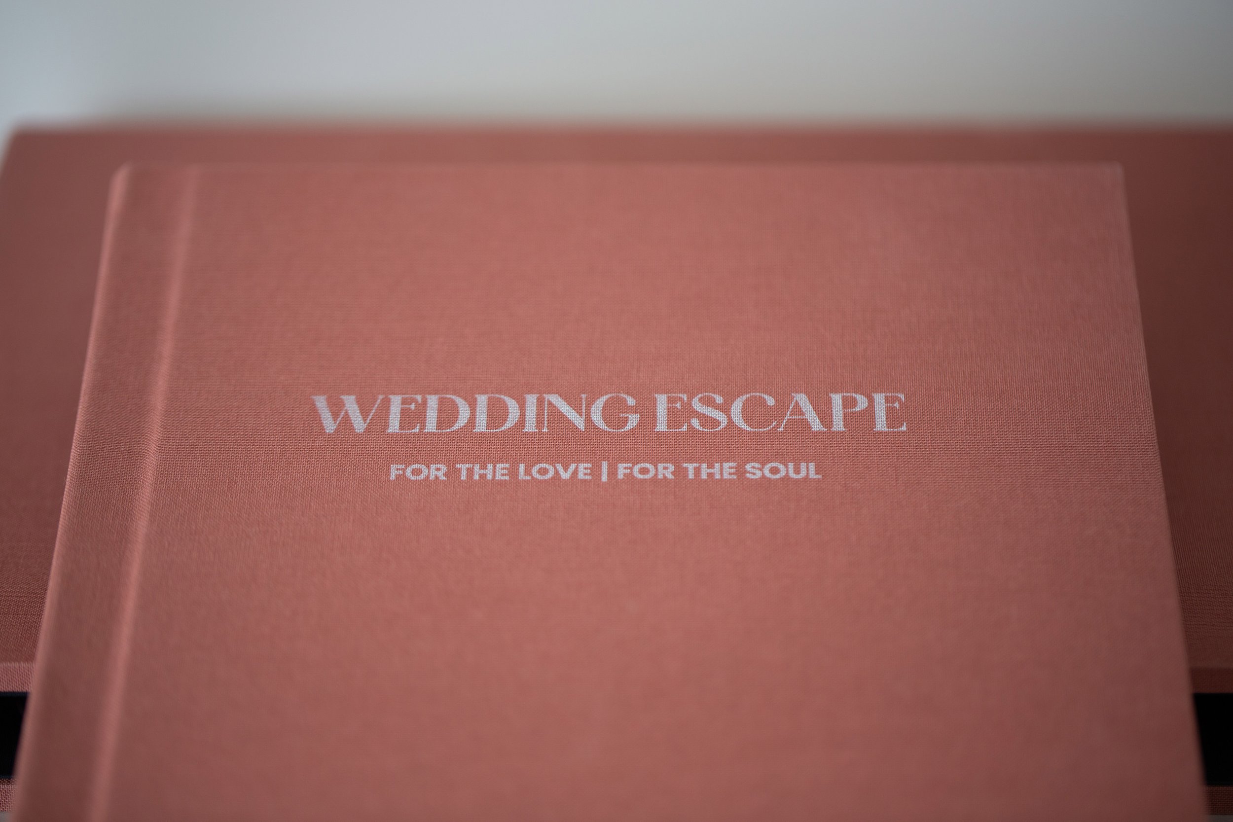 Ein pinkfarbiger Briefumschlag mit weißer Aufschrift 'WEDDING ESCAPE' und dem Slogan 'FOR THE LOVE | FOR THE SOUL'.