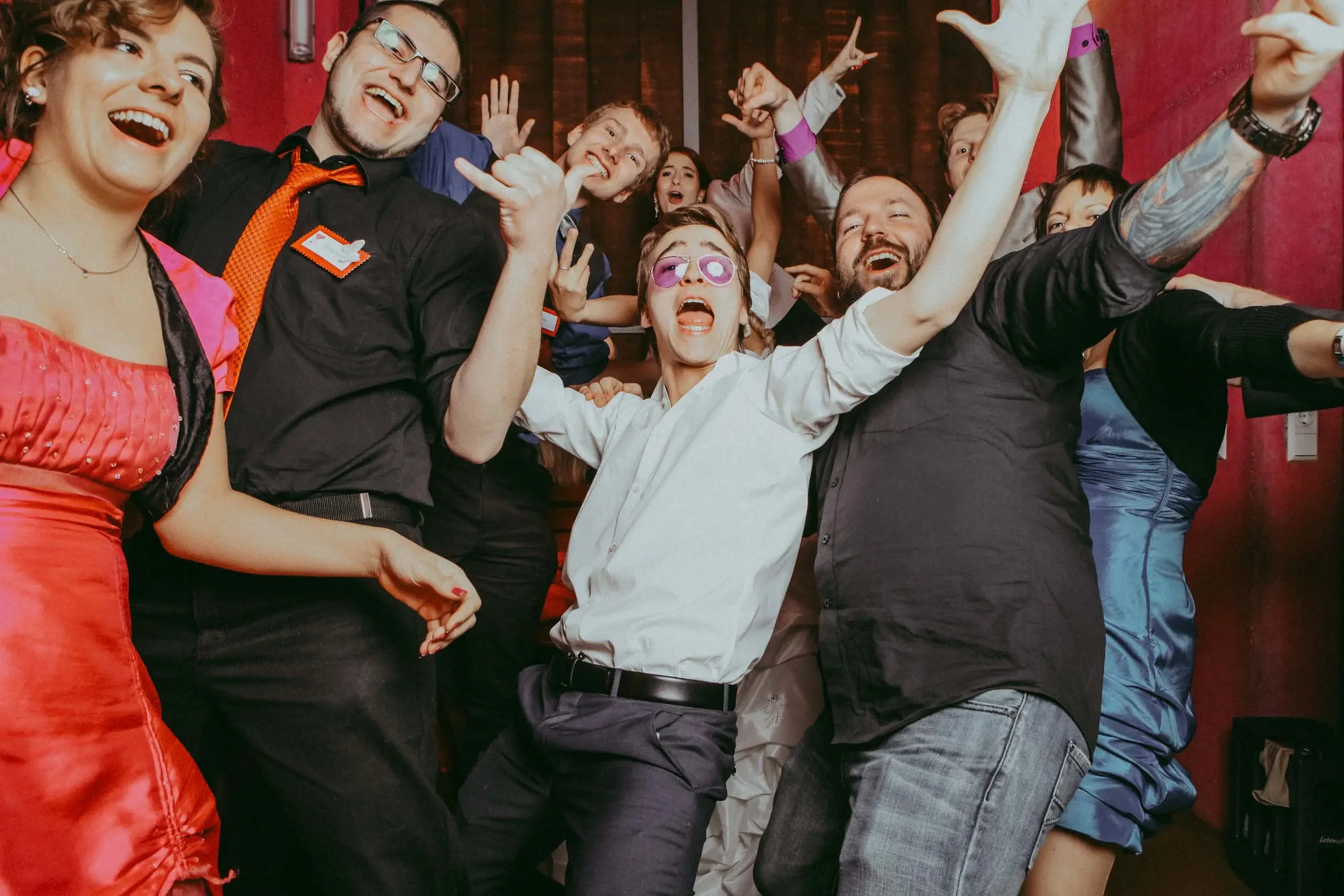 Eine grosse Gruppe Hochzeitsgäste feiert ausgelassen vor der Fotobox