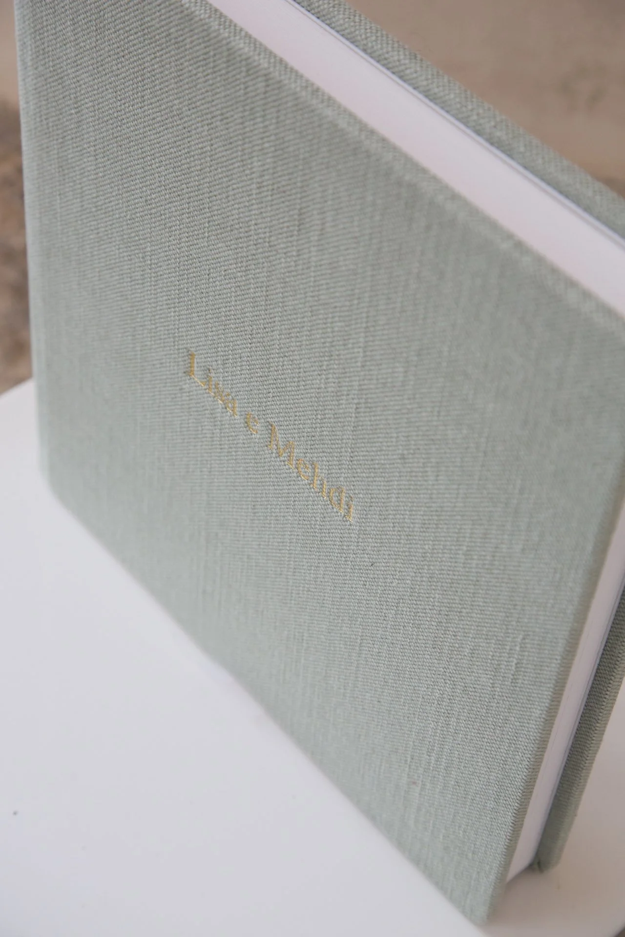 Ein beige farbener Buchdeckel mit goldener Schrift, der den Titel »Lust & Melancholie« trägt, auf einer weißen Oberfläche