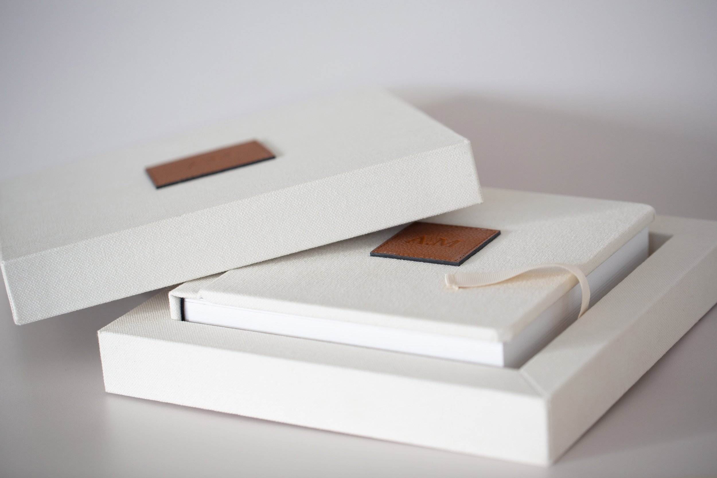 Weiße Box mit Bücher, die jeweils ein braunes Etikett tragen, auf dem 'AIM' steht.