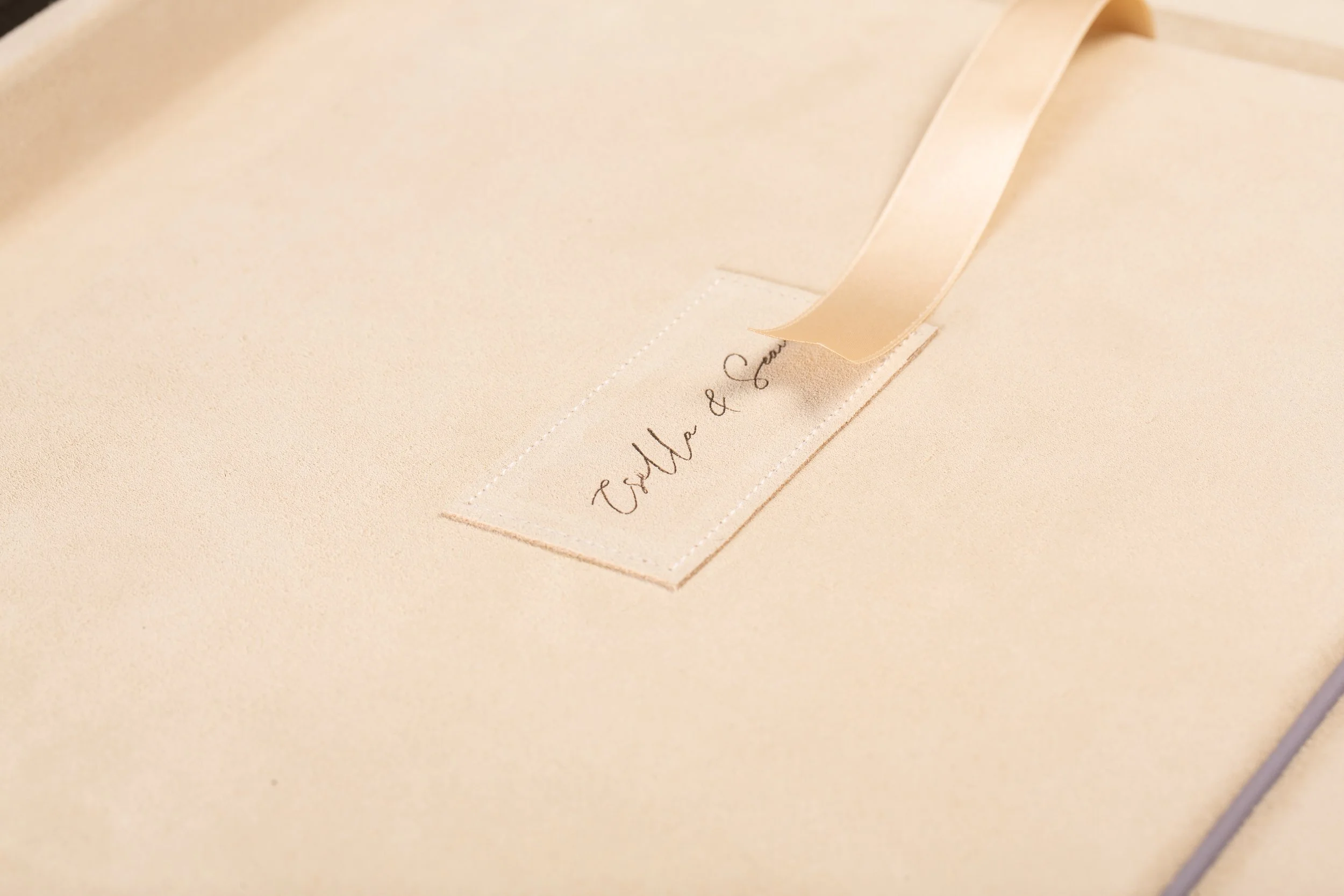 Nahaufnahme eines beigefarbenen Papiers mit einer eingewachsenen weißen Banderole, auf der in eleganter Schrift 'Otto & Co' steht.