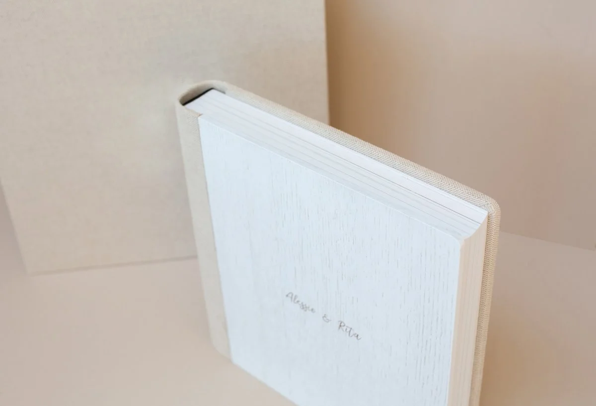 Weiße Hardcover-Buch mit Schriftzug 'Aline & Riva' auf der Titelseite, gedreht, um einen weißen Hintergrund.