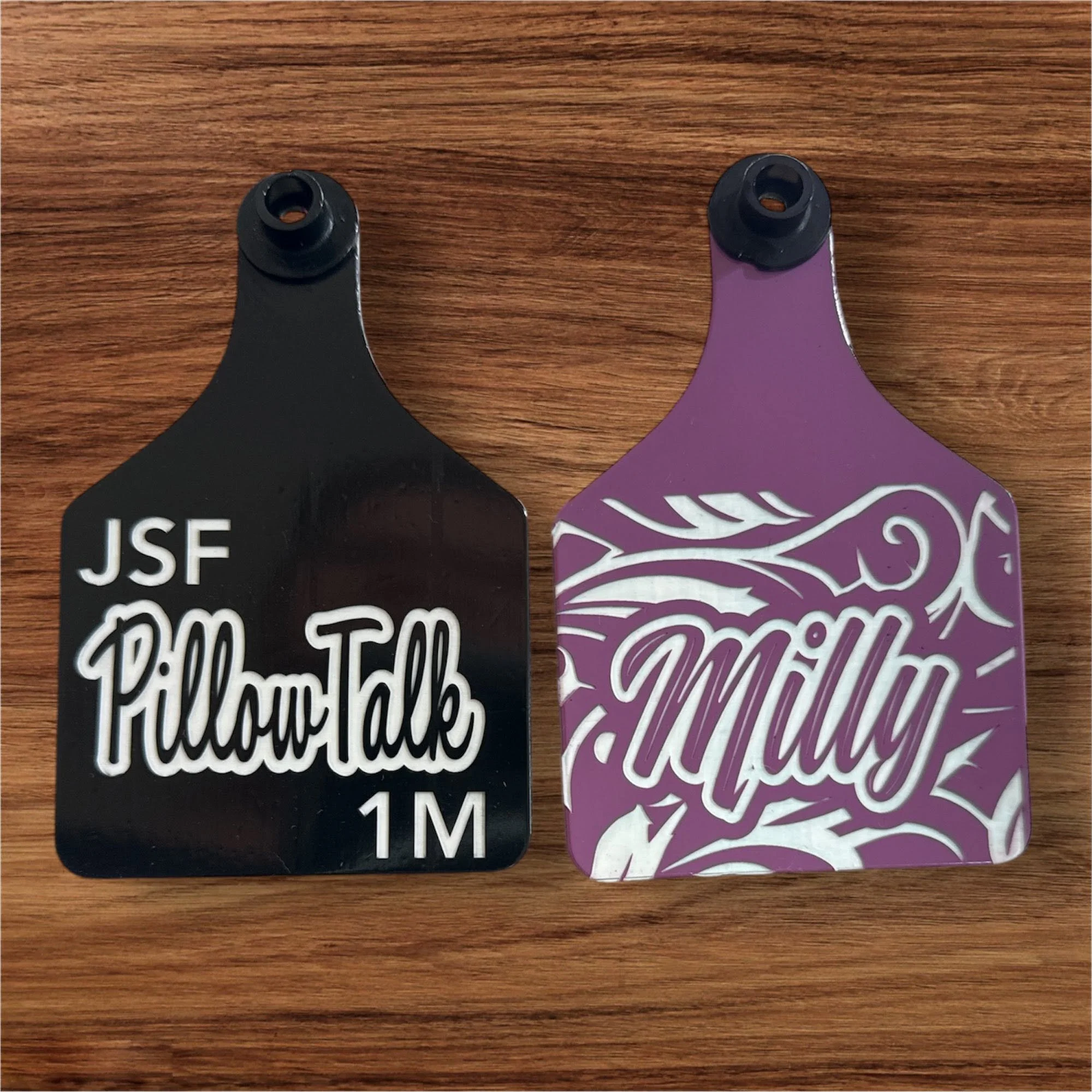 Close-up of two health or fitness cards with finger holes, black and purple in color, placed on a wooden surface.