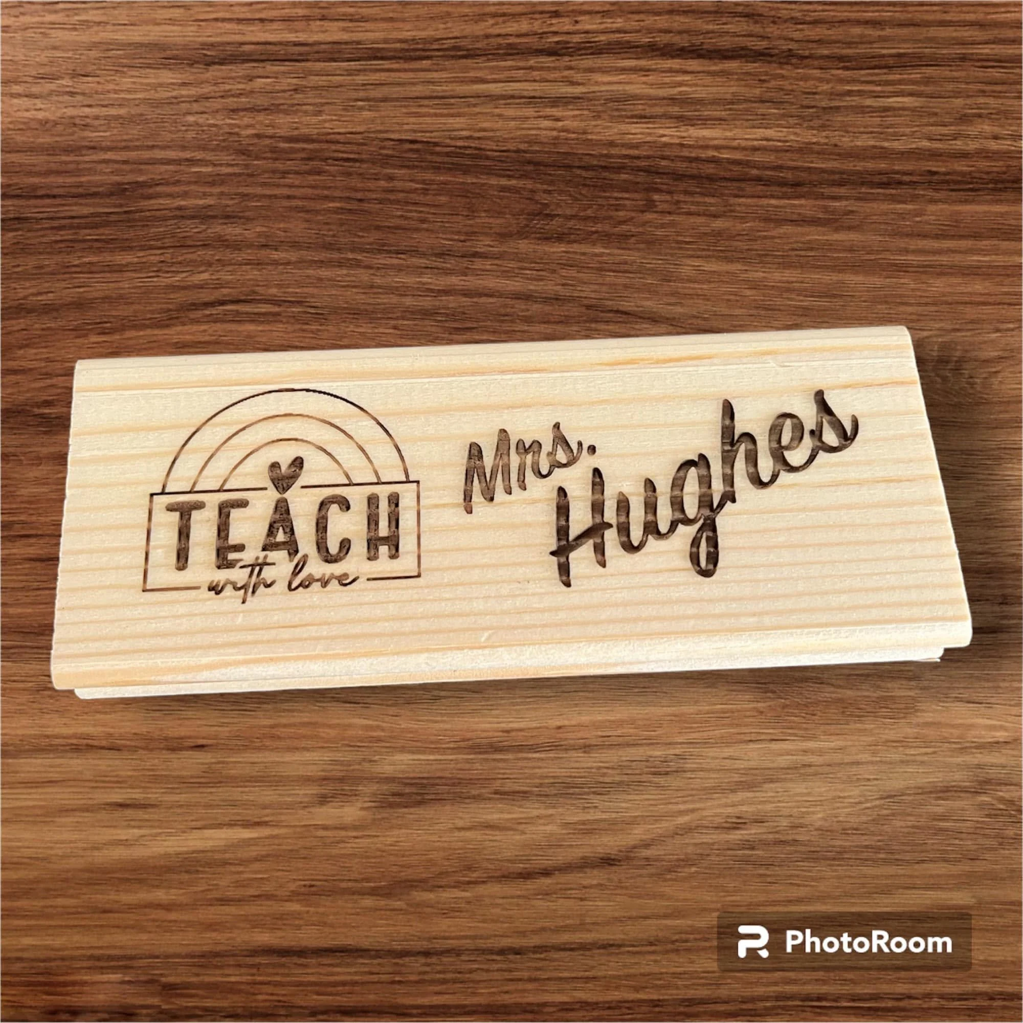 Close-up of a wooden surface with engraved text and designs.