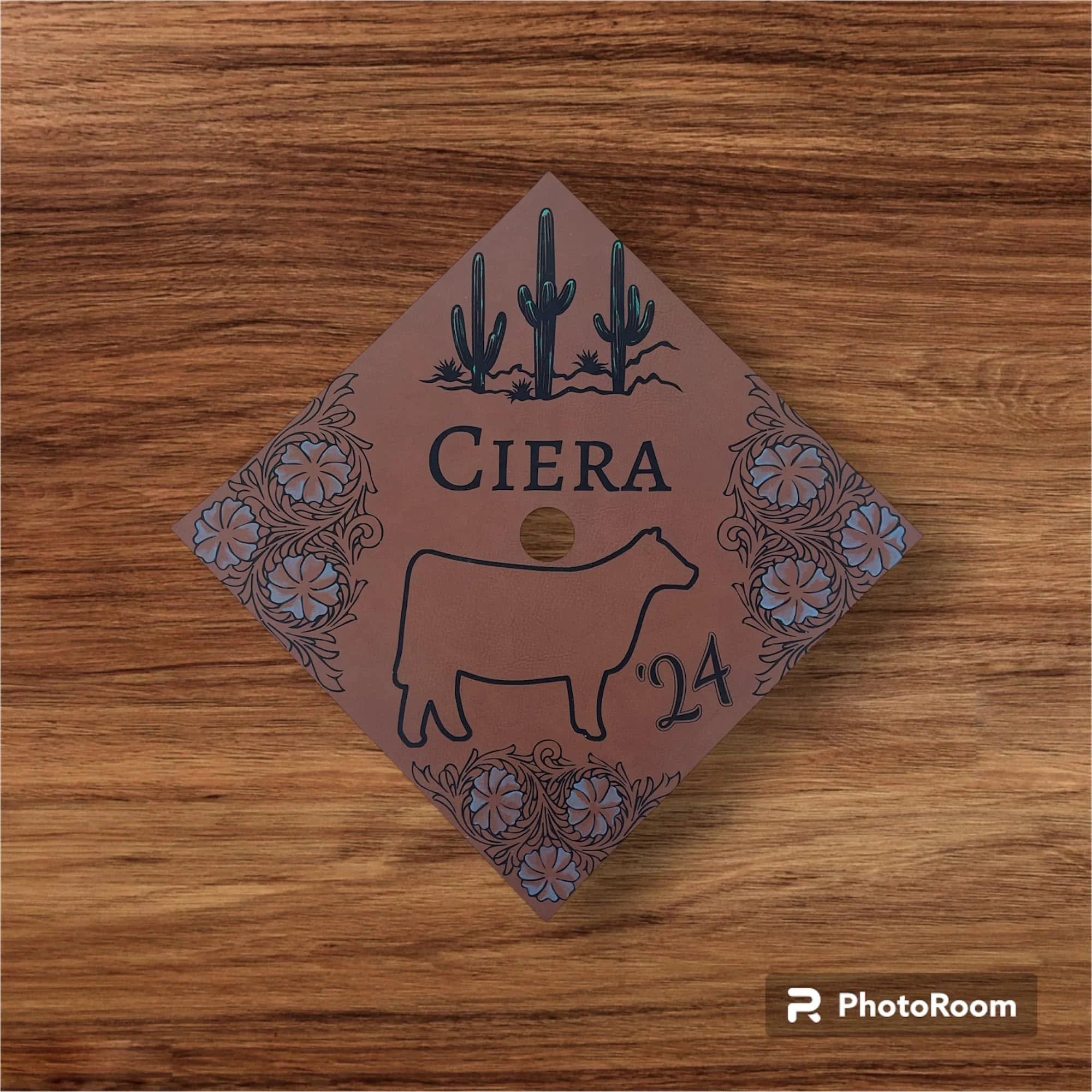 A cardboard package with a cactus illustration and floral designs, lying on a wooden surface. The package features the branded word "CERA" and the number "204".