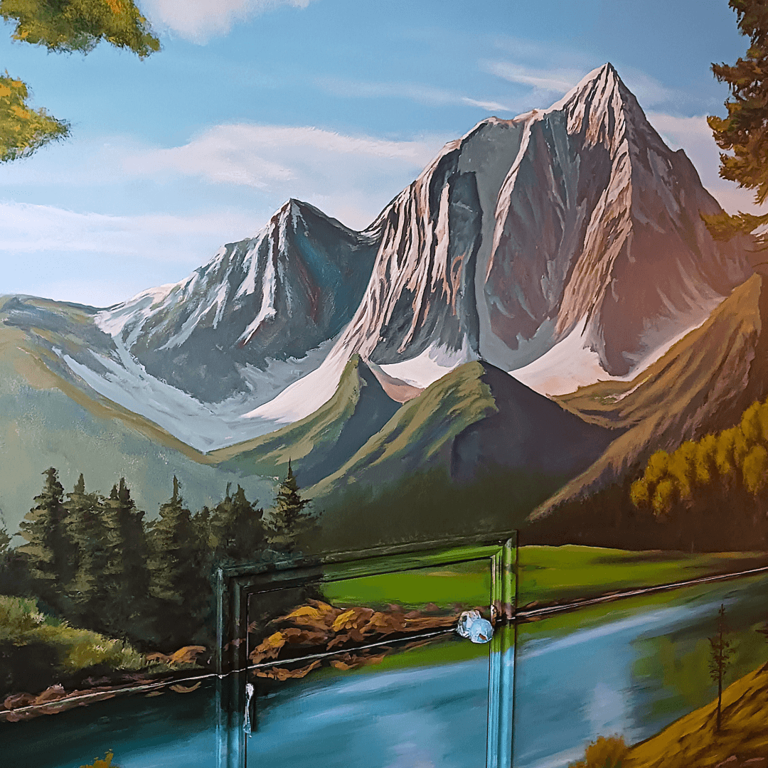 A painted mural of mountain landscape with towering snow-capped peaks, green forested slopes, and a calm river in the foreground.