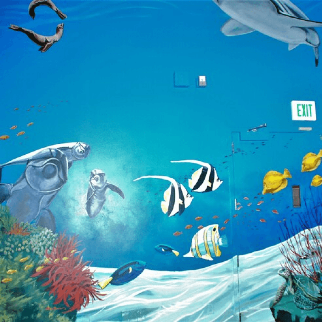 Colorful underwater mural with various fish, coral, and aquatic life, including a large shark, whales, and smaller fish, on a blue background.