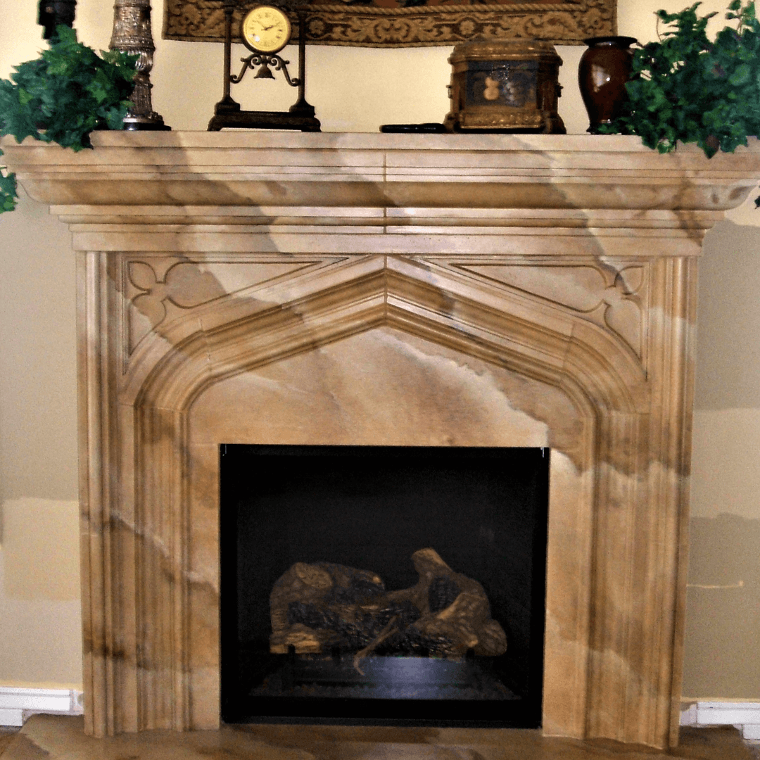 Marble fireplace with decorative molding and a wood mantel, topped with a clock, plants, and decorative boxes.
