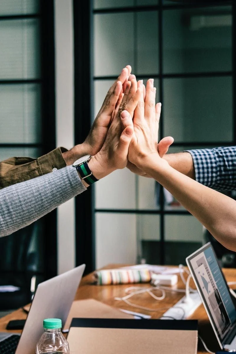 Two people giving each other a high five in an office setting.