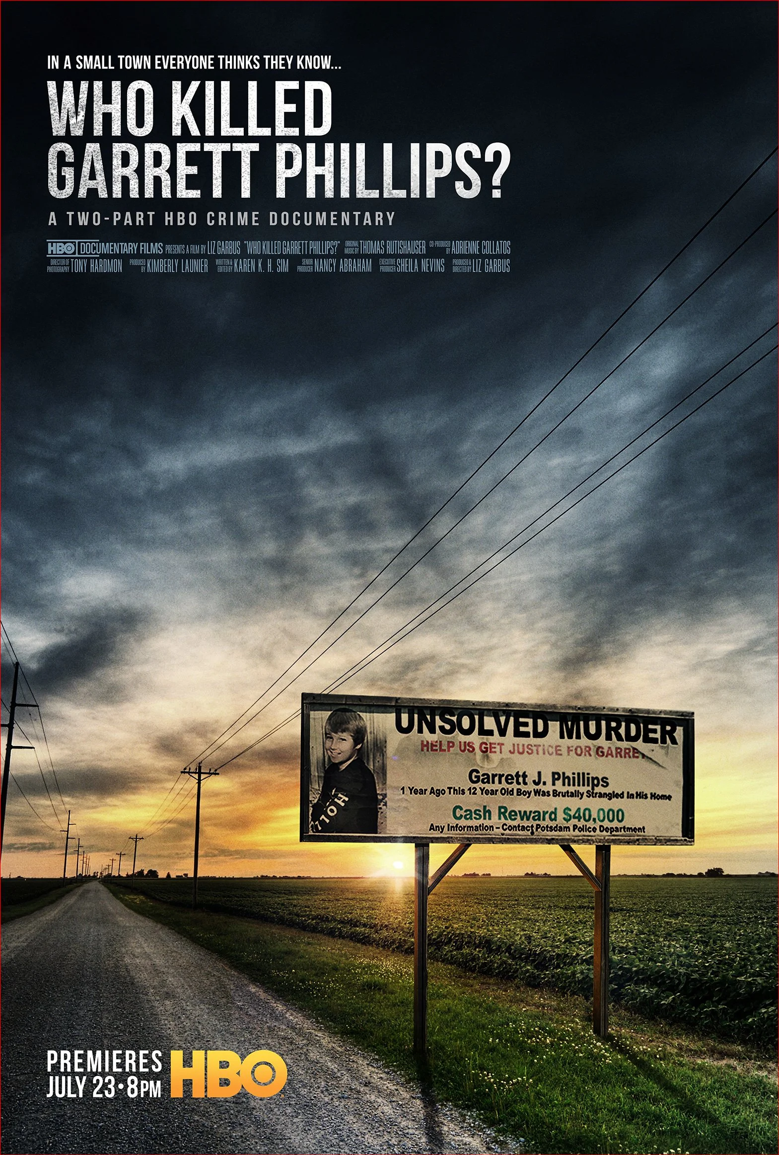 A billboard on a rural road at sunset with an indefinite landscape, promoting the HBO documentary 'Who Killed Garrett Phillips' about a 12-year-old boy's murder, offering a cash reward of $40,000 for information.