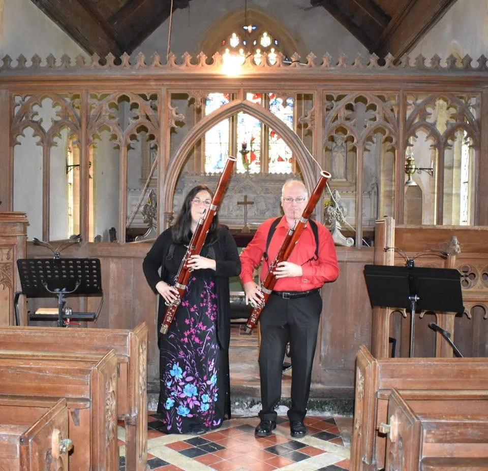 Katy and Miles playing bassoons in a church