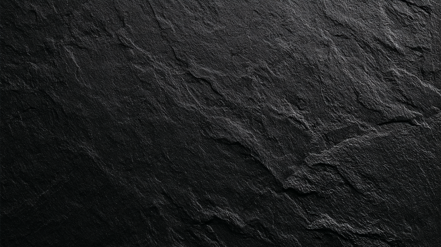 Close-up of a dark, textured stone surface with visible cracks and roughness.