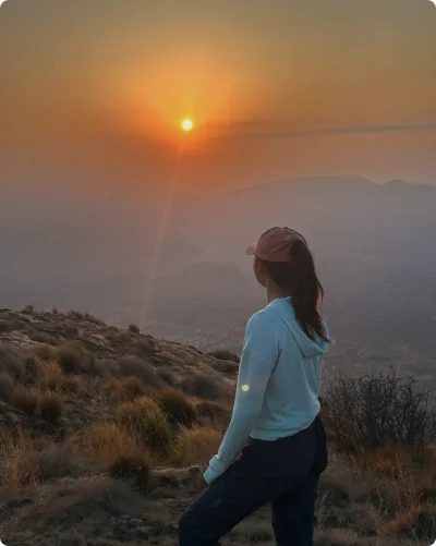 Eugenia watching the sunset from a mountain peak.