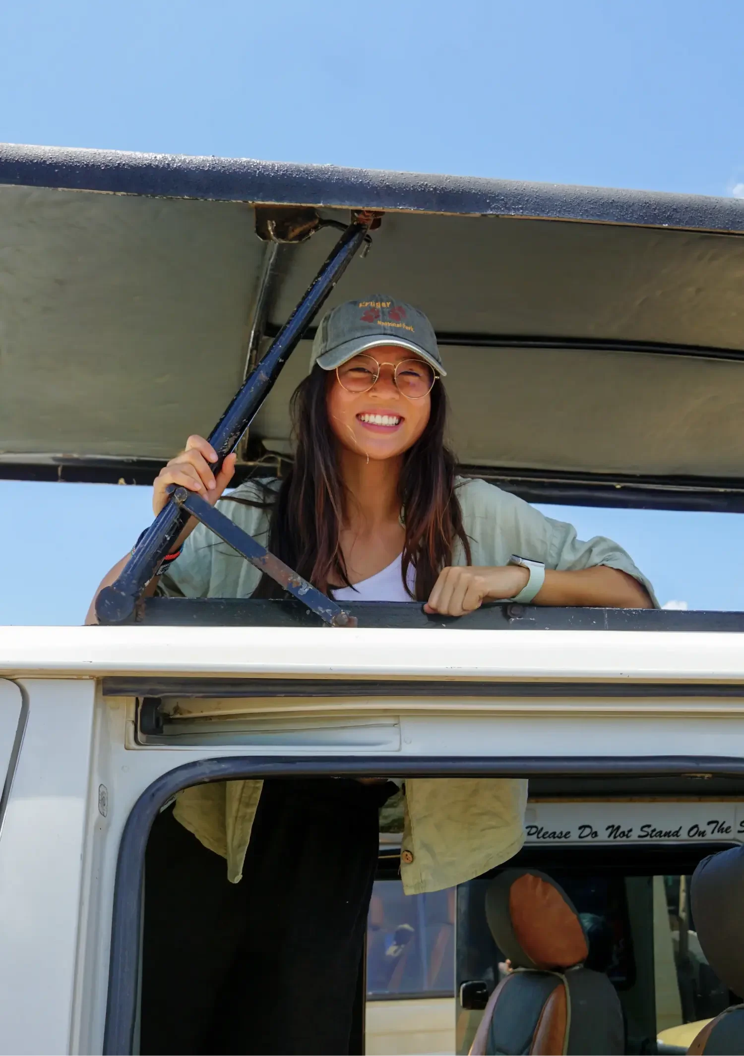 Eugenia smiling from the roof of a safari truck during a conservation travel experience.