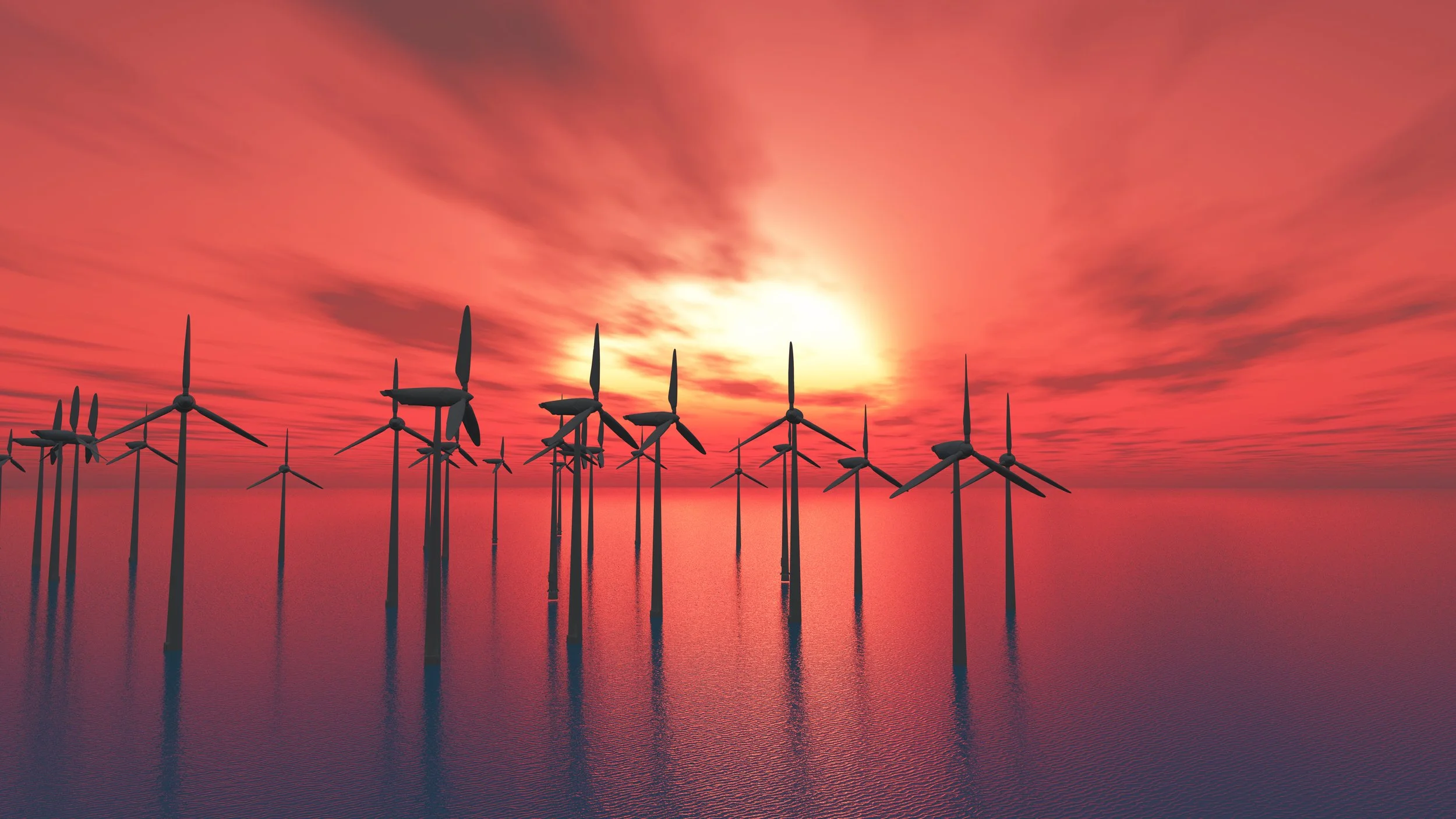 Wind turbines in the ocean at sunset with a colorful sky and clouds.