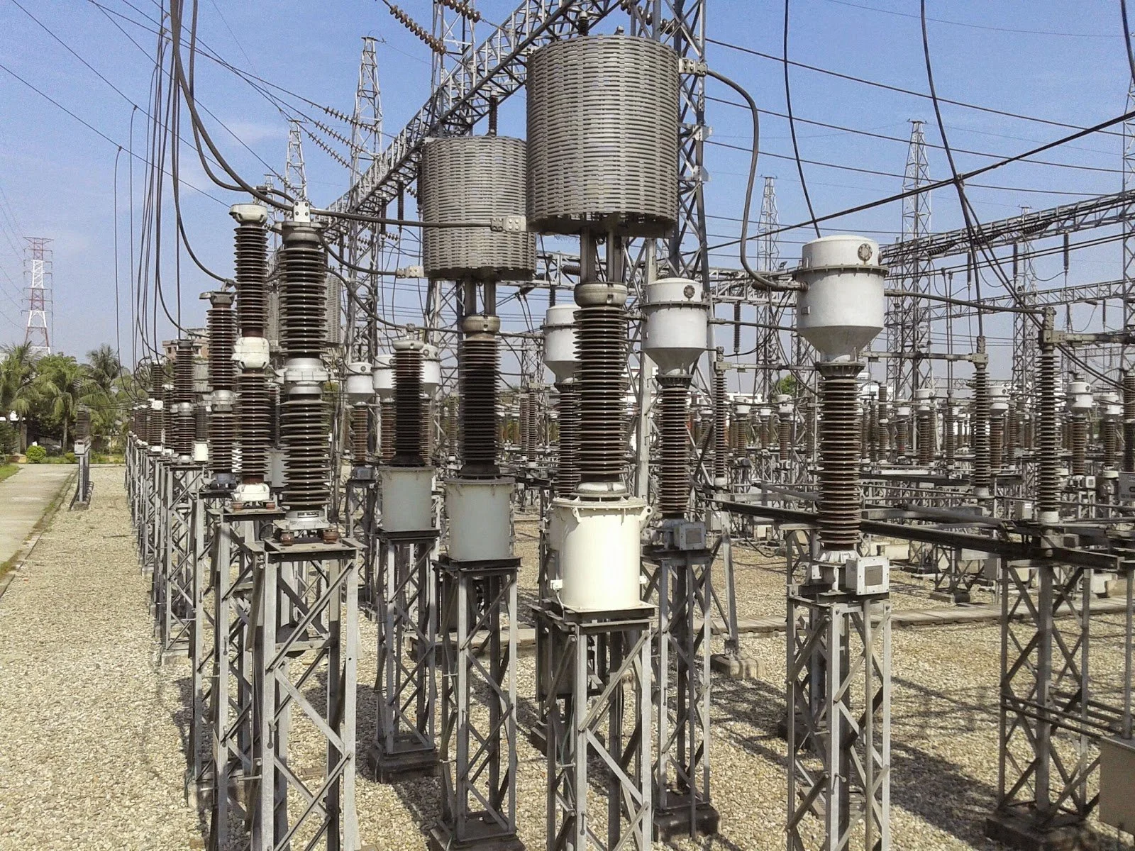An outdoor electrical substation with high-voltage power lines, transformers, and insulators.
