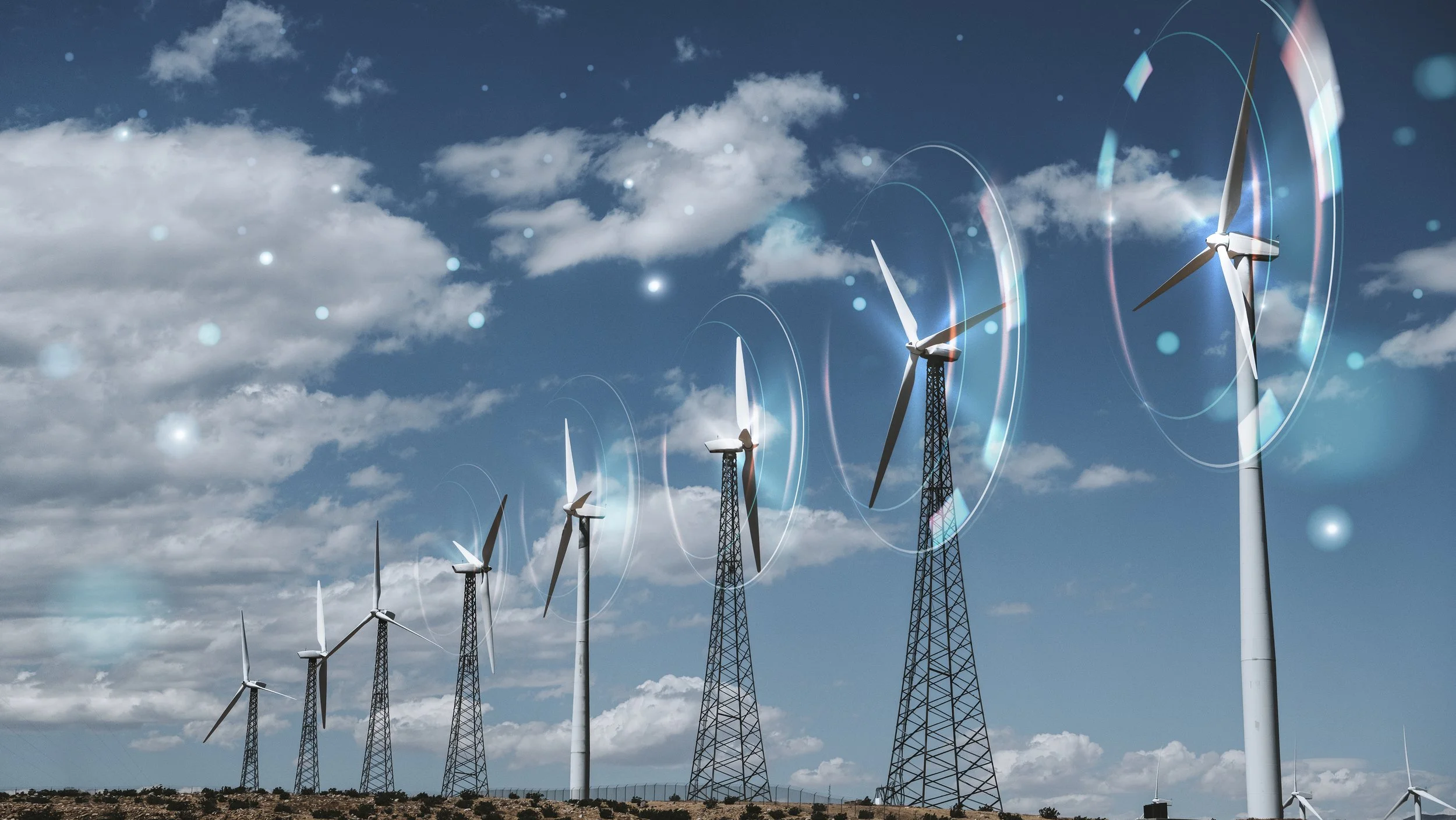 Multiple wind turbines on a landscape with a partly cloudy sky.