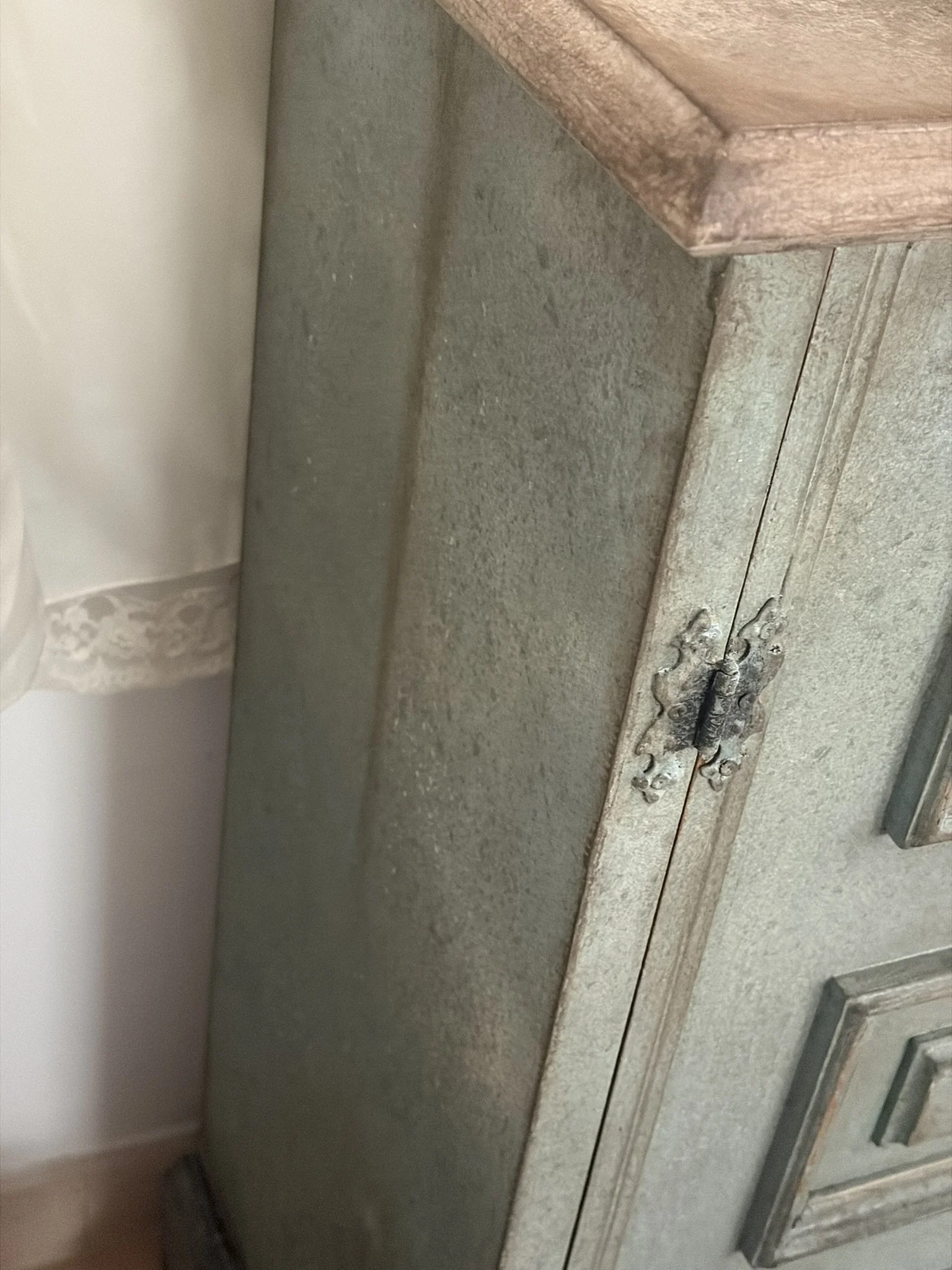 Foto di un angolo di una stanza con pareti e mobili di legno e marmo, una superficie di marmo grigia e un mobile in legno con motivo decorativo vintage.
