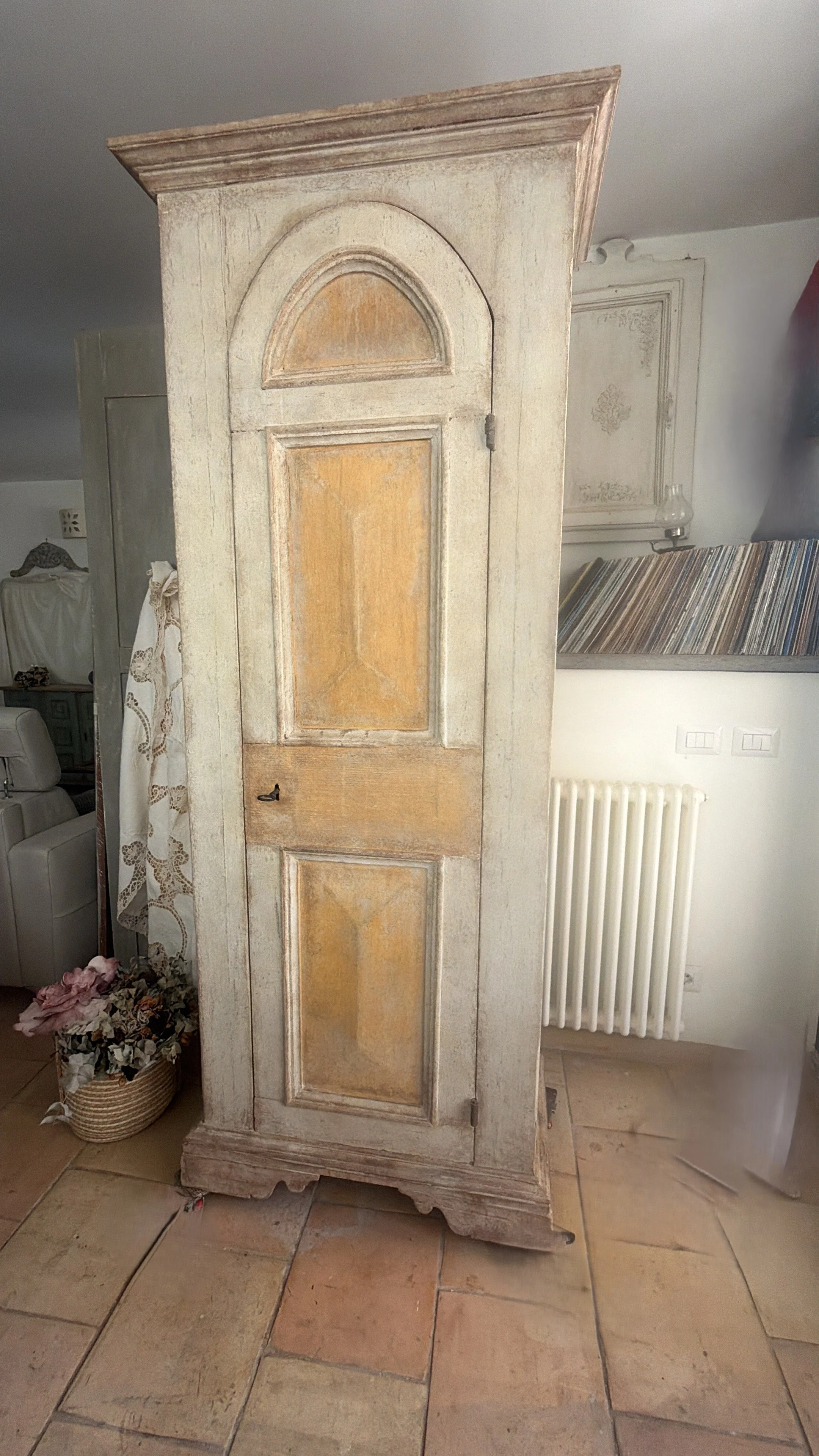 Una porta in stile vintage con un design invecchiato, con pannelli in toni di beige e marrone chiaro, posizionata in un ambiente domestico.