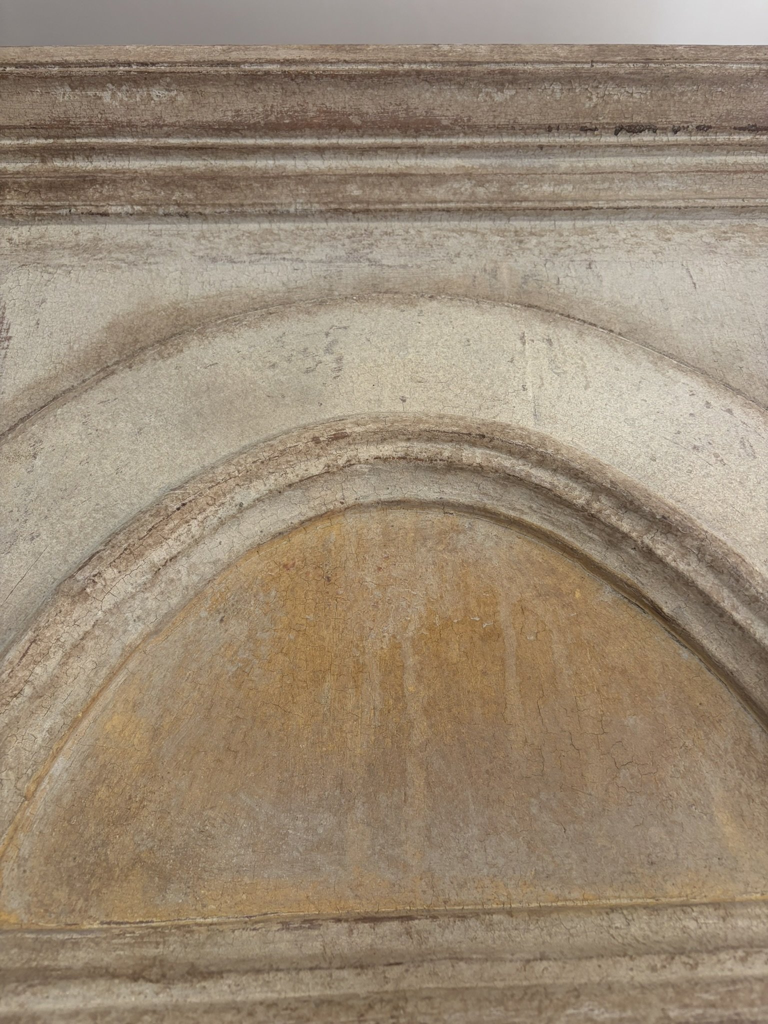 Un'immagine di un arco in pietra con dettagli e superfici usurate.