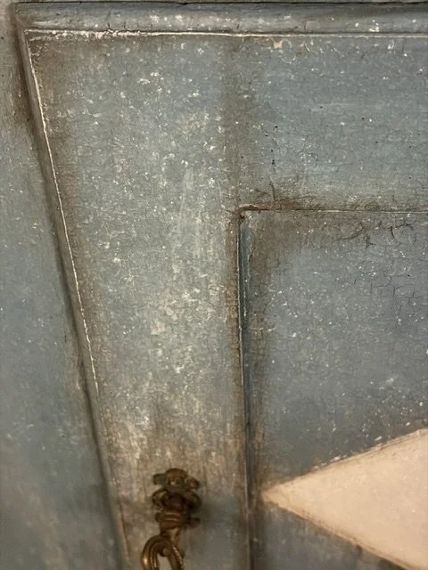 Dettaglio di una superficie metallica con una vite arrugginita e una cordicella.